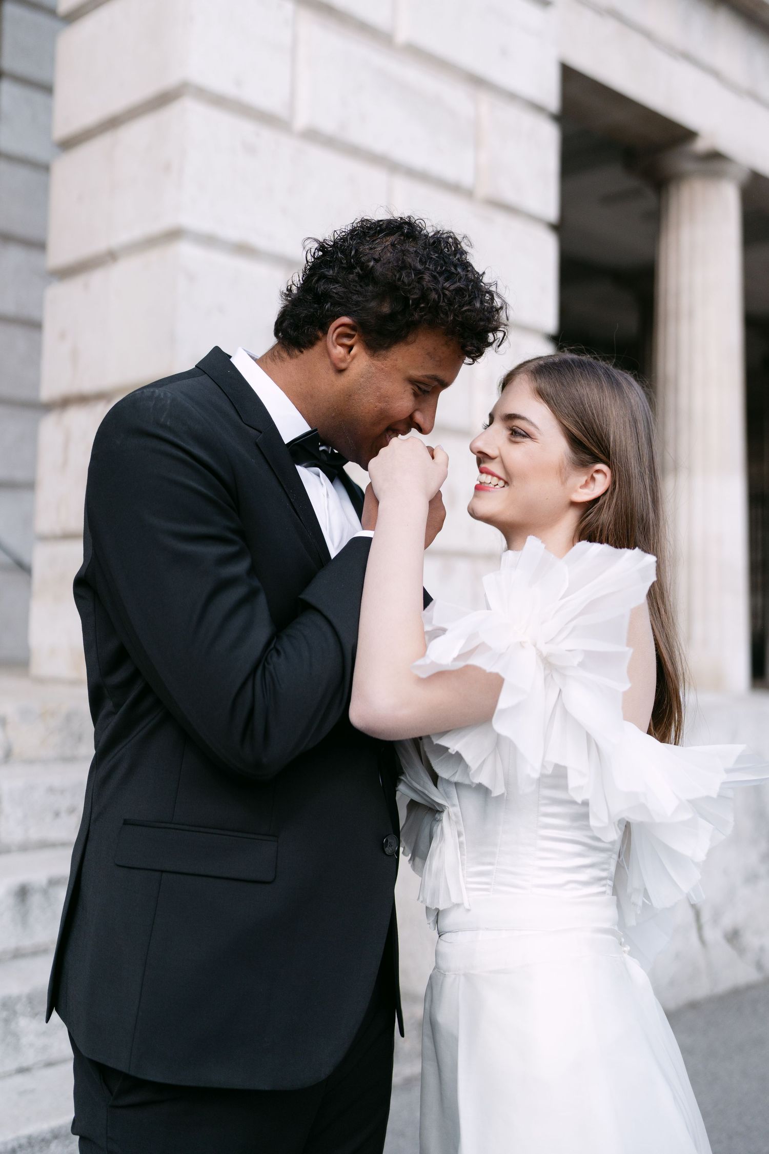 Intimate black and white portrait of a couple in formal wedding attire.