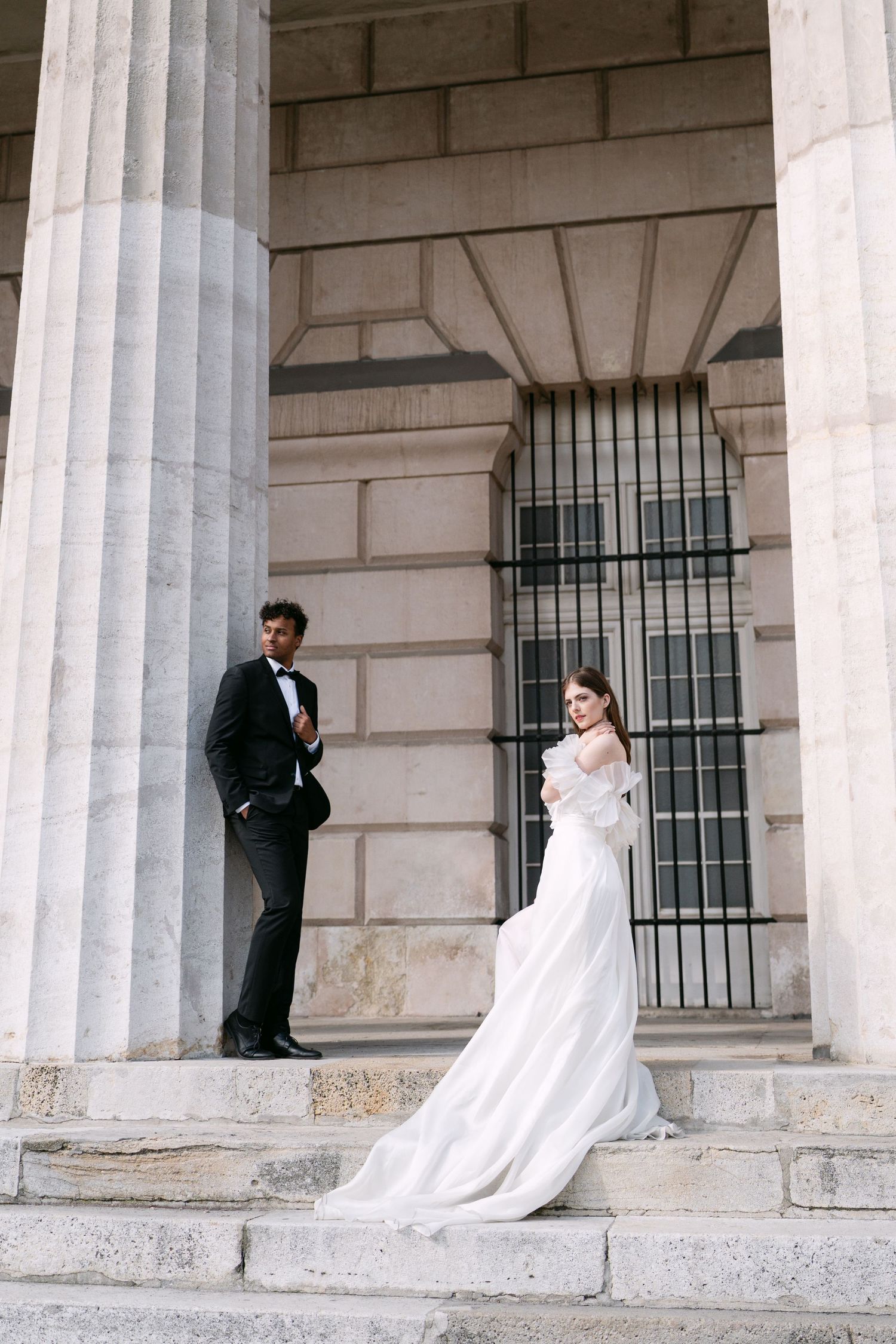 Romantic wedding portraits against classical stone columns and architecture.
