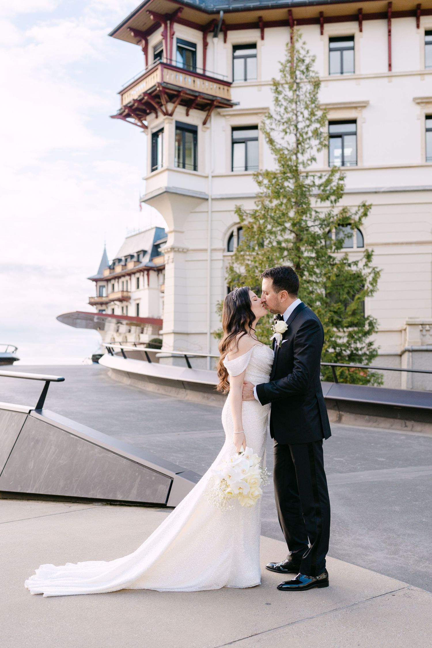 Wedding couple sharing intimate moment on rooftop terrace of elegant building.