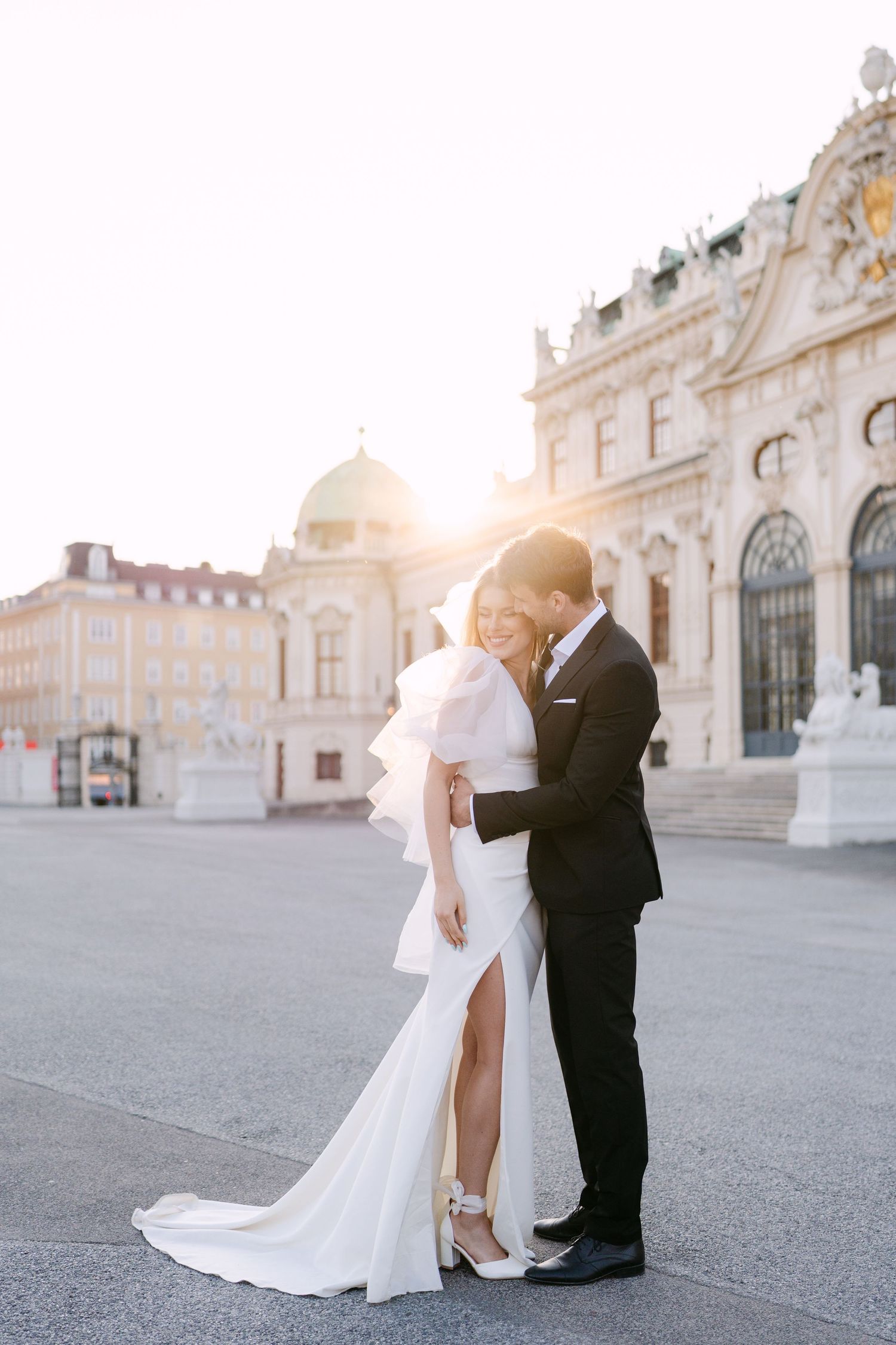 A glamorous wedding photo in front of the Belvedere Palace in Vienna at golden hour.