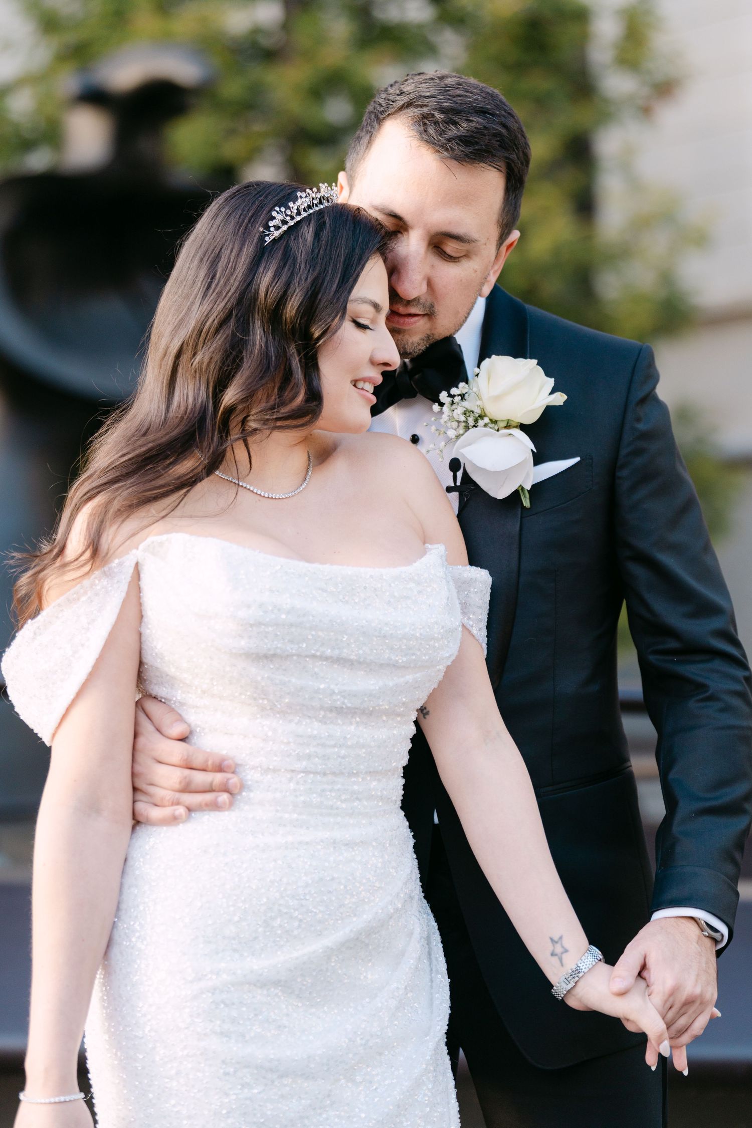 Romantic wedding couple embraces in a series of intimate portraits showing the bride in a white sequined dress.