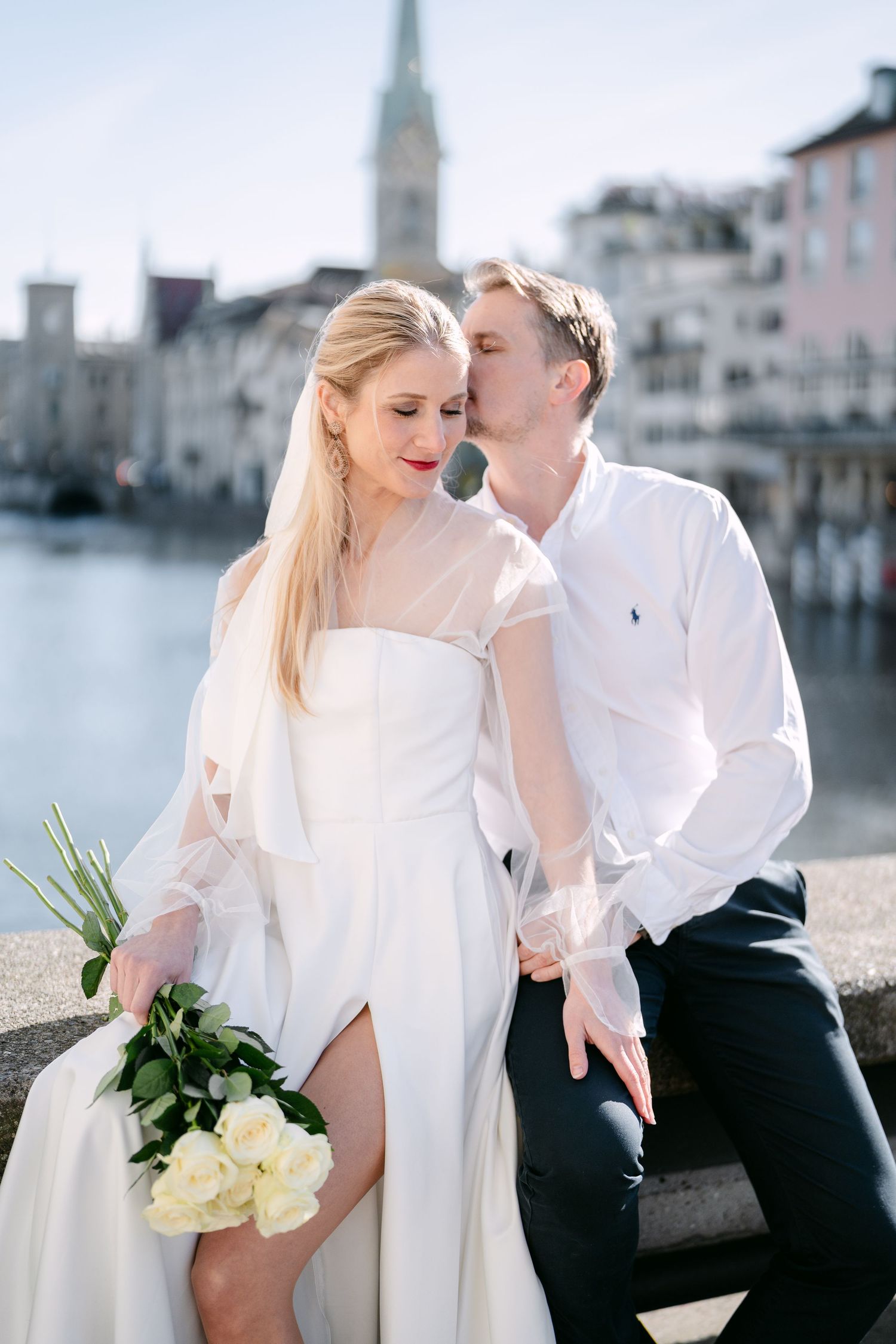 Romantic waterfront wedding photos with white roses and classic European architecture.