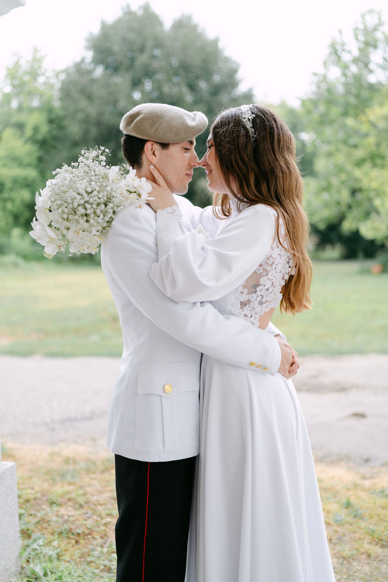 Romantic outdoor portrait of couple in white attire with delicate floral details.