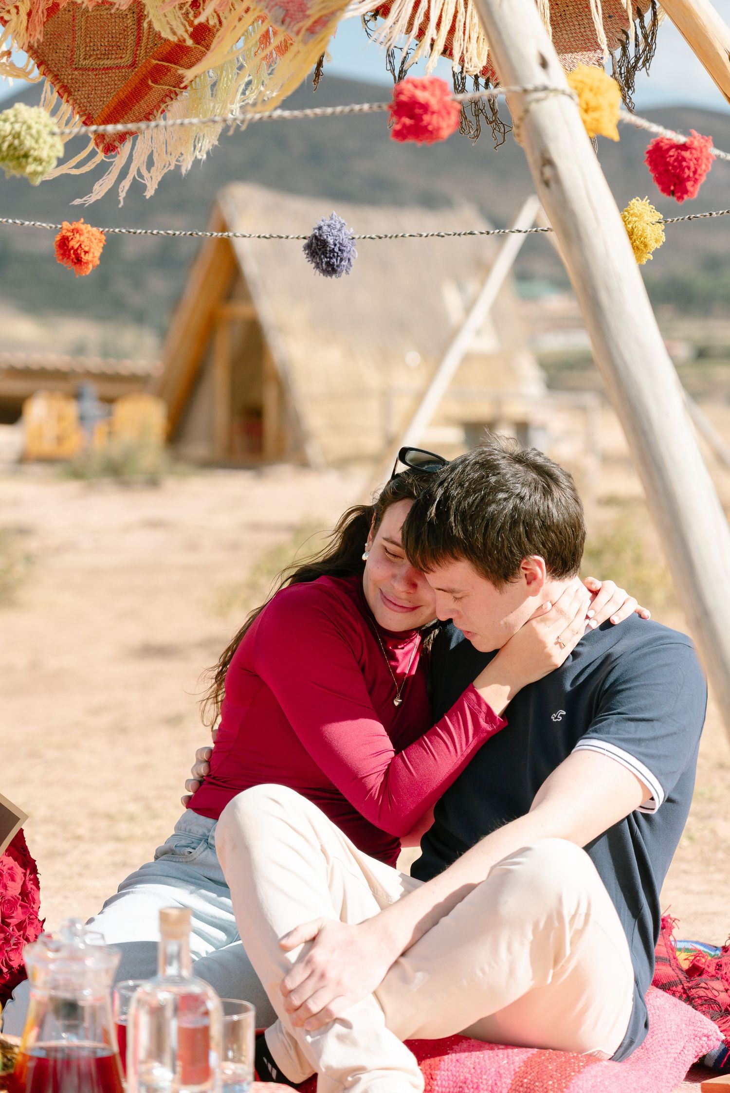 Romantic desert picnic scene with decorative hanging elements and mountains in background.