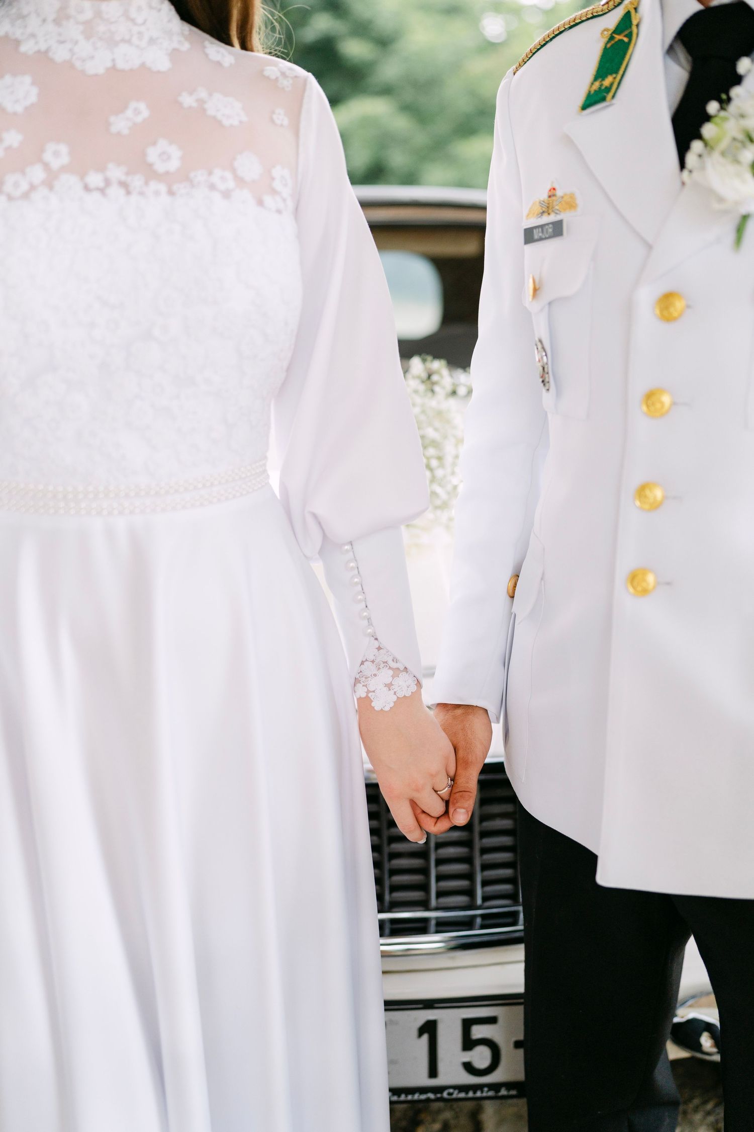 Close-up details of white formal military uniforms with gold buttons and decorations.