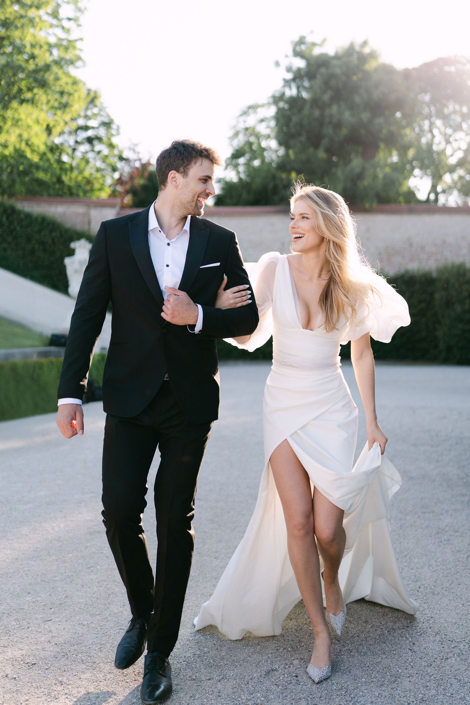 Joyful wedding couple runs and laughs together during outdoor photo session.