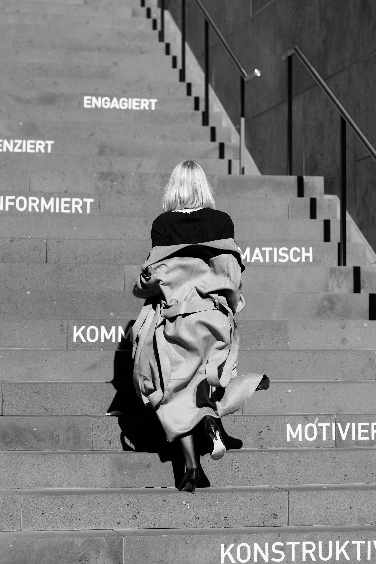Artistic black and white photo sequence showing movement on concrete steps with German text.