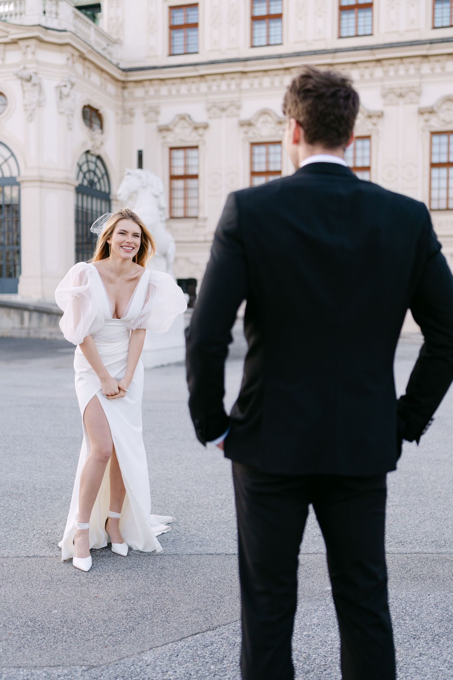 Elegant wedding photo shoot outside a historic palace with ornate architecture.