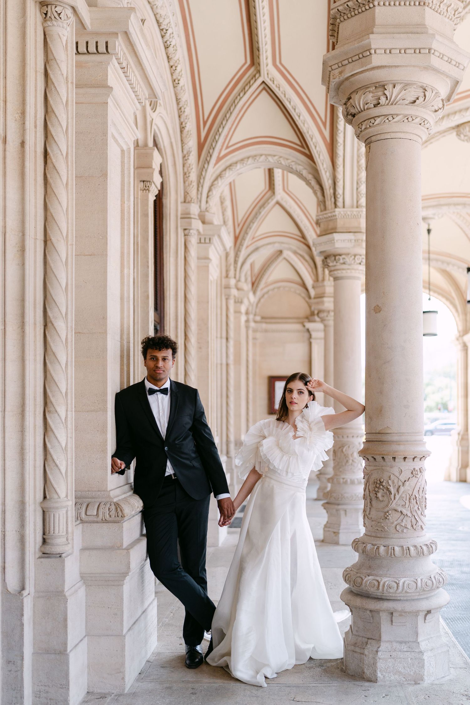 Elegant wedding photos captured in classical architecture with ornate columns.