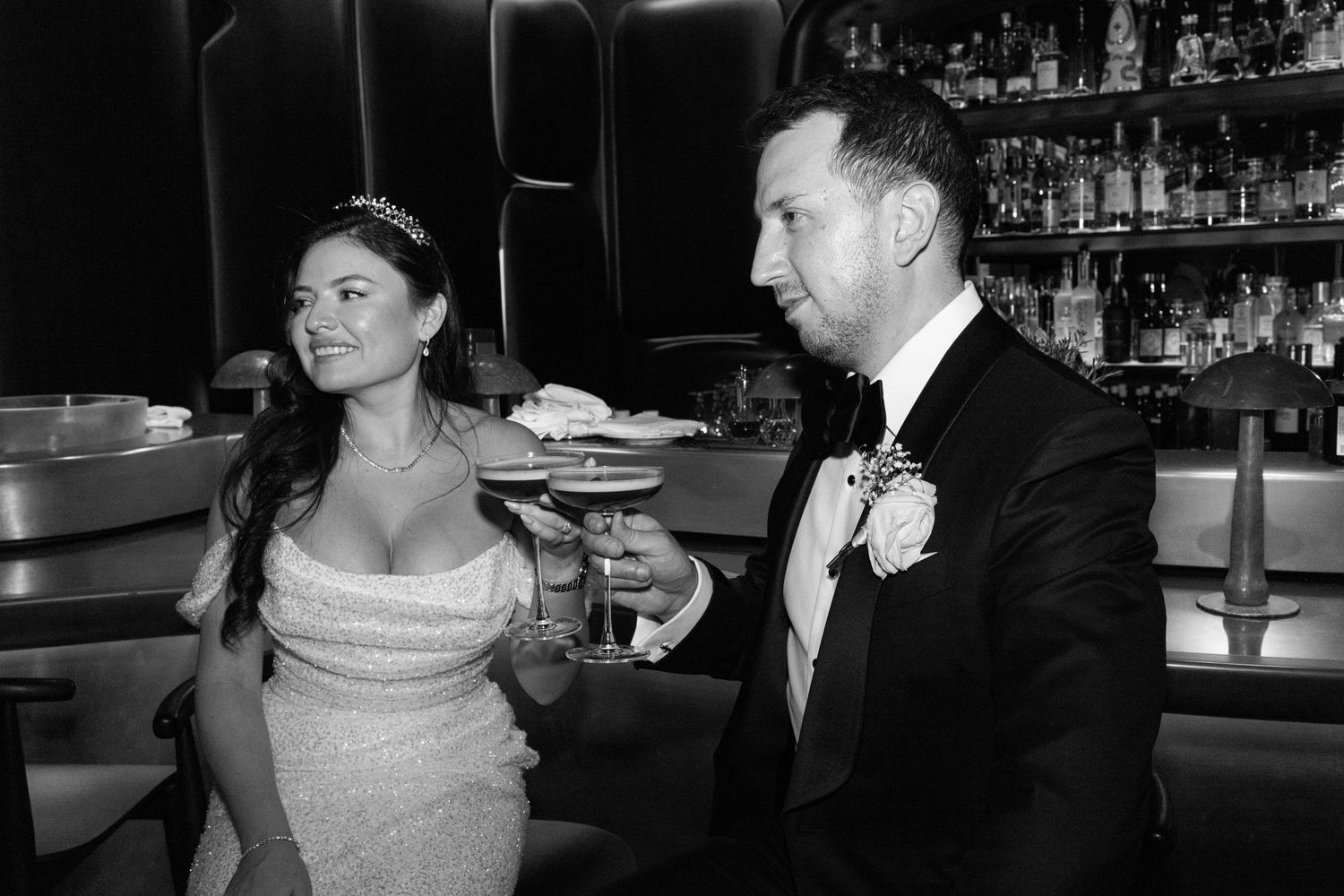 Elegant black and white photos of a couple at a bar in formal wedding attire.