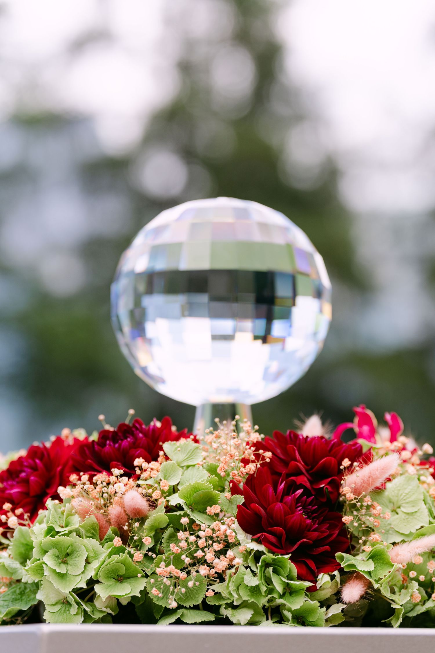 Crystal ornaments and red flowers decorate an outdoor event display.