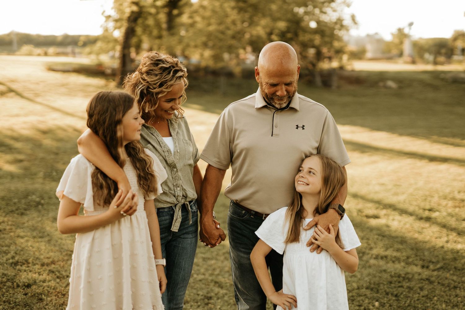 A happy family shares a candid moment together outdoors during sunset.