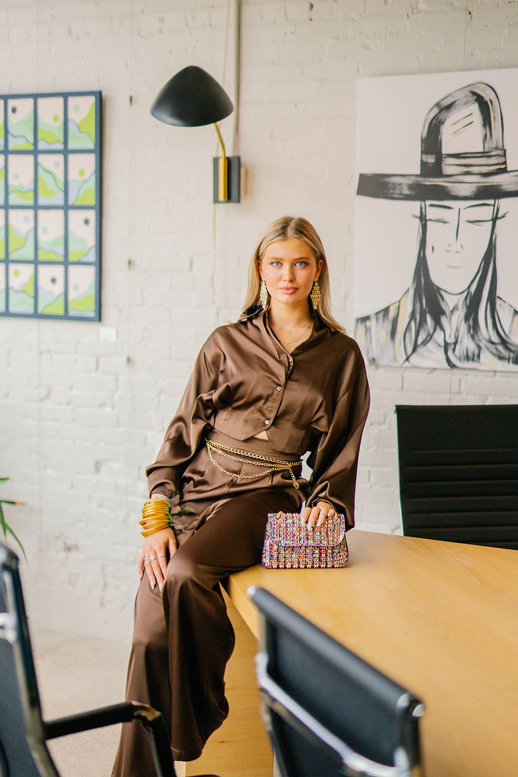 Professional fashion photo session in a modern office space featuring a brown outfit.