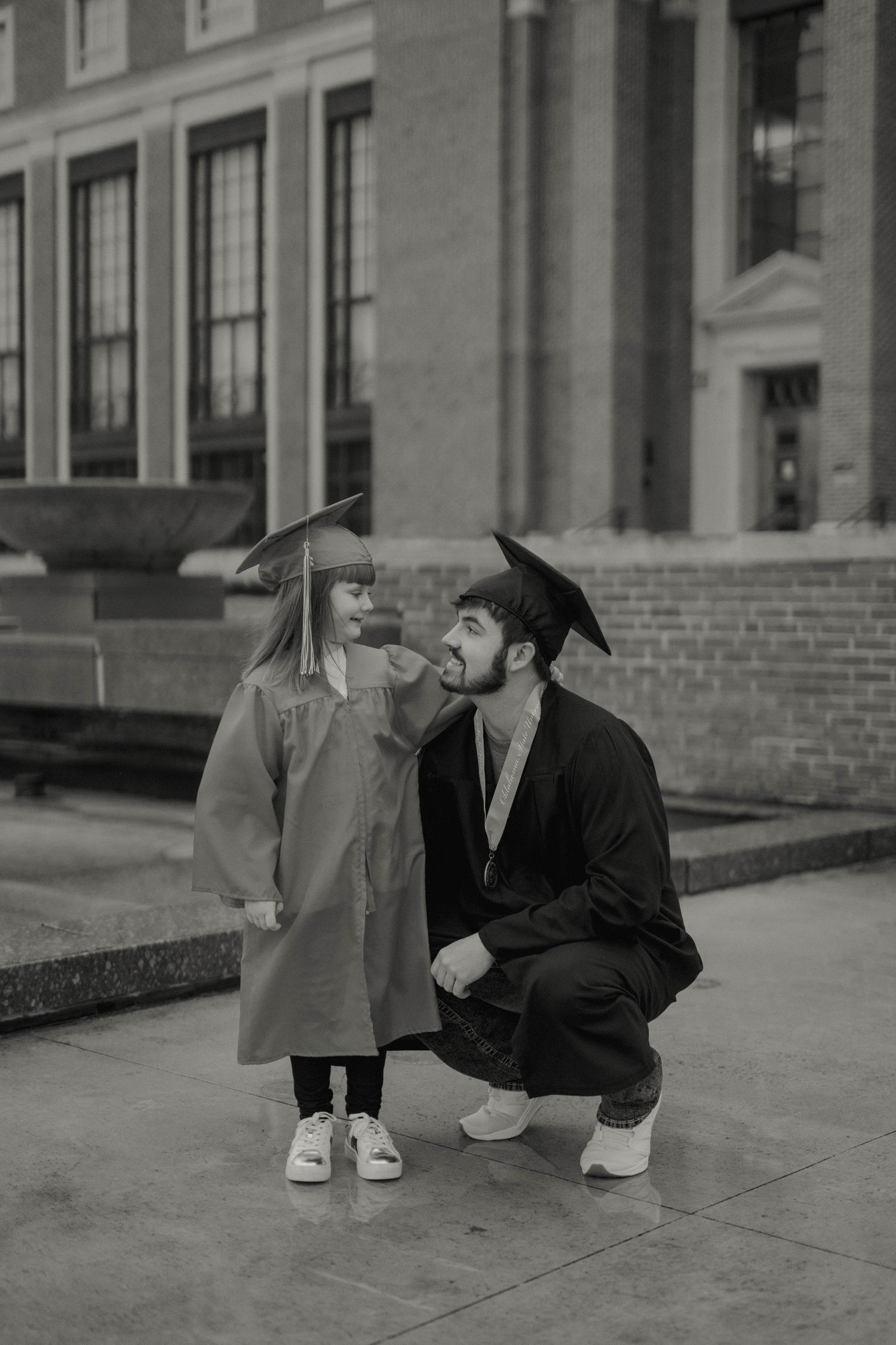 Black and white photo of graduation moment outside historic building.