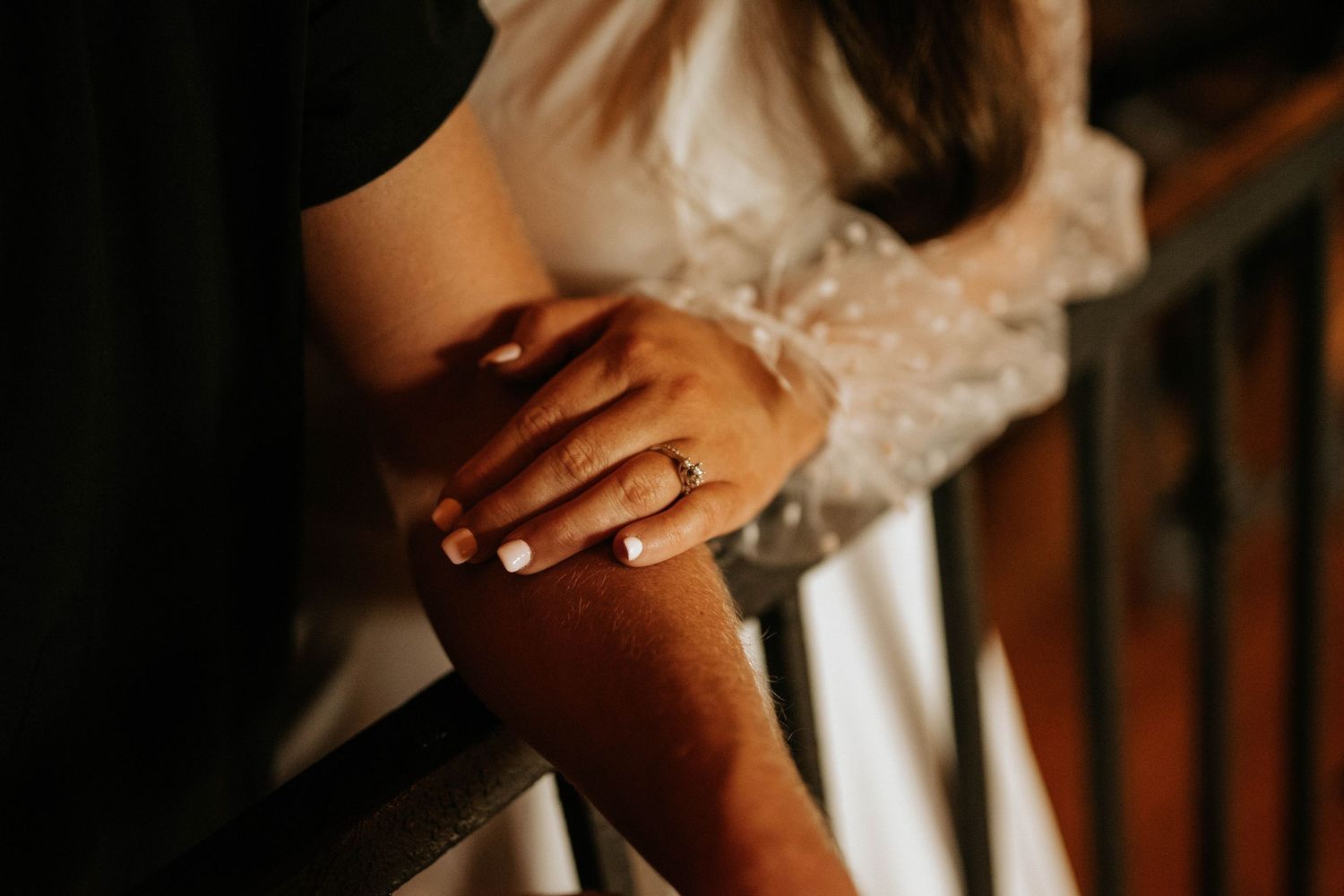 Close-up details of rings and hands during an intimate moment.