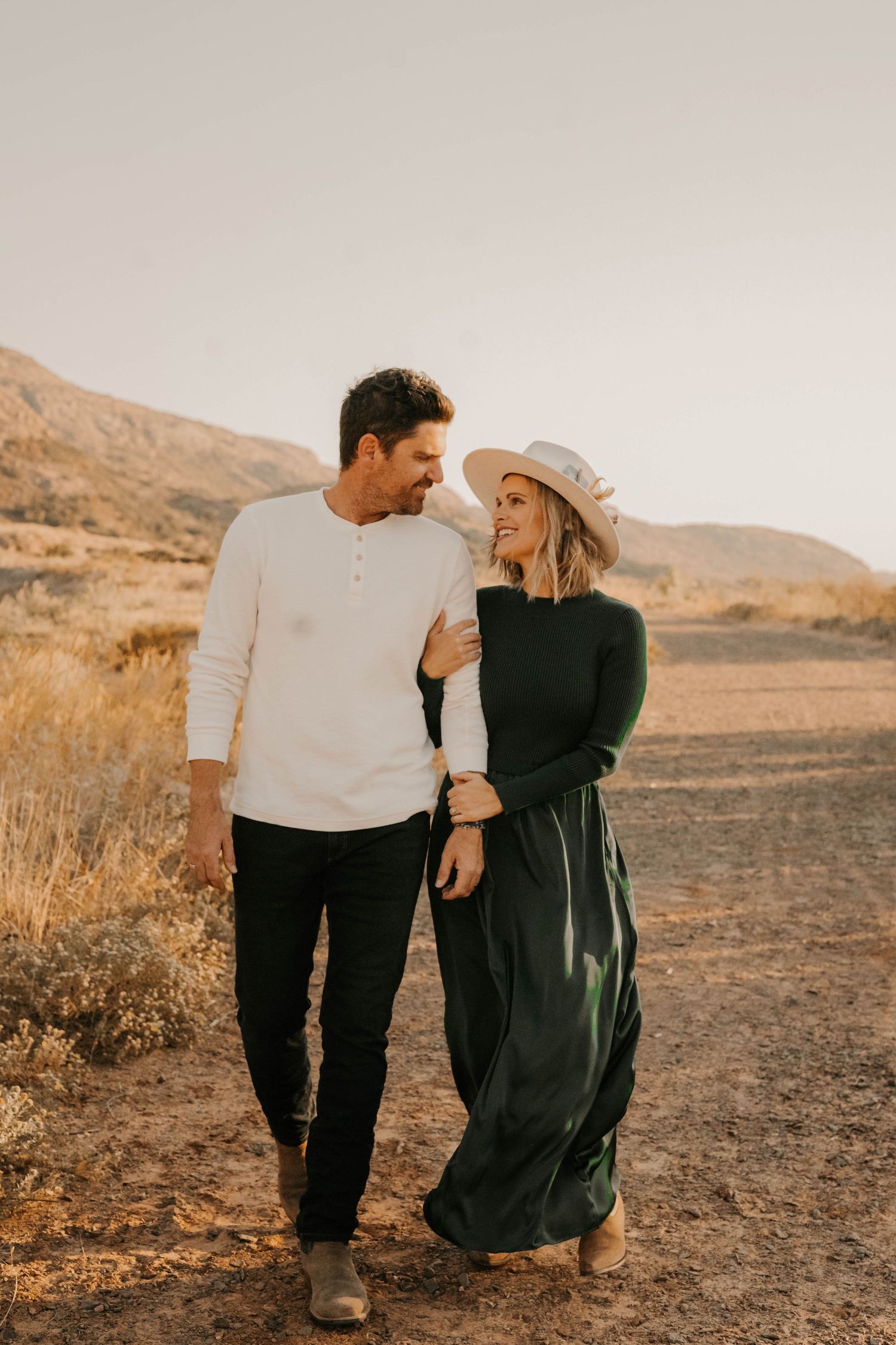Intimate couple portrait in desert landscape during golden hour.