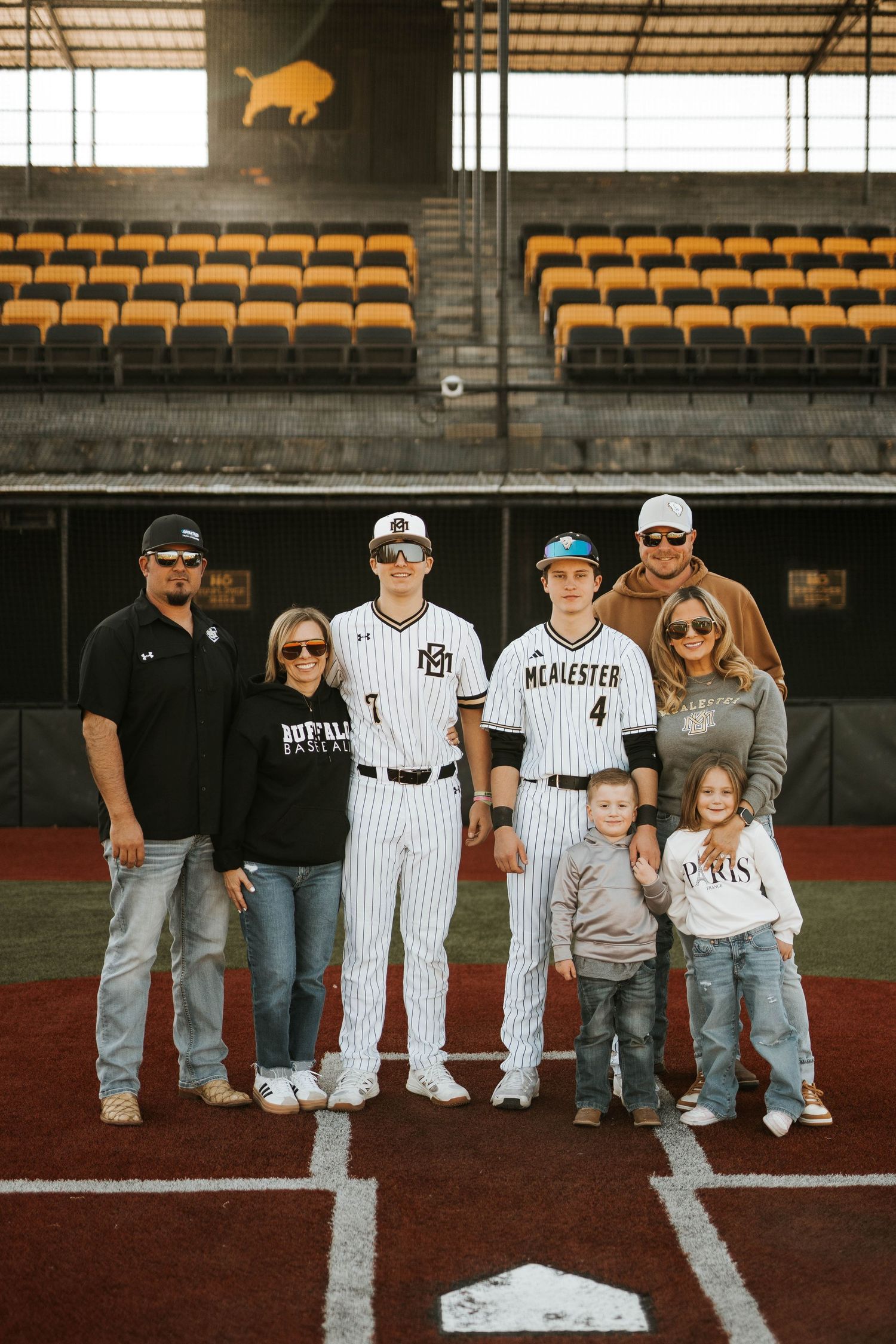 Extended family group photo on baseball field with stadium seating and distinctive buffalo logo visible.