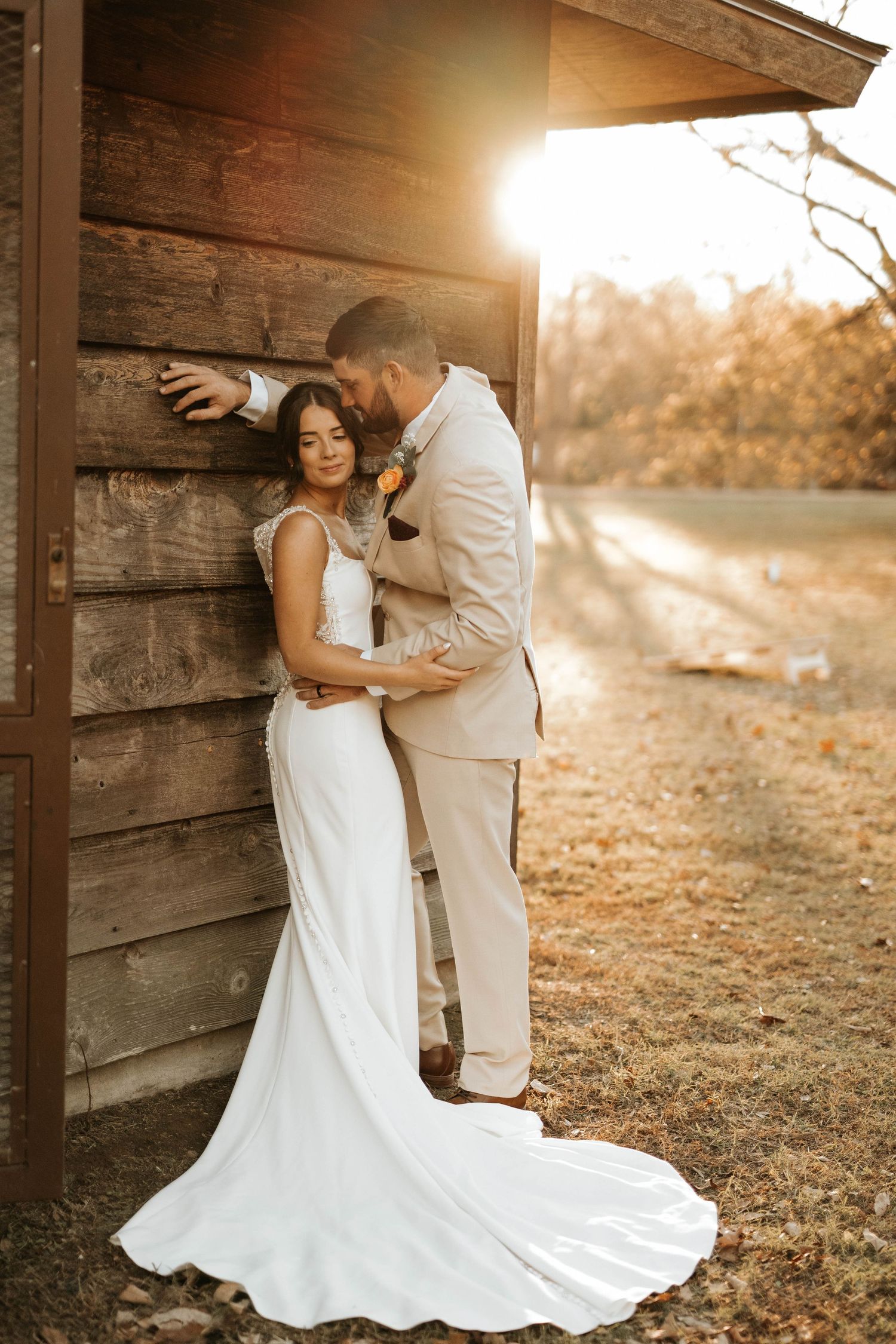 A romantic wedding moment captured against a rustic cabin at golden hour.