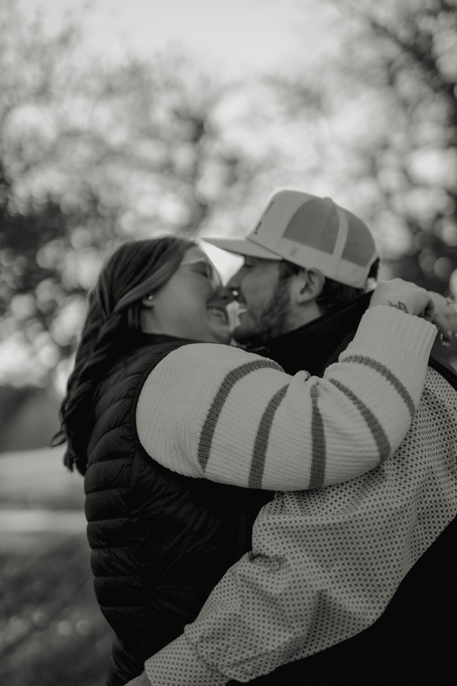 Intimate black and white portrait of couple embracing outdoors.