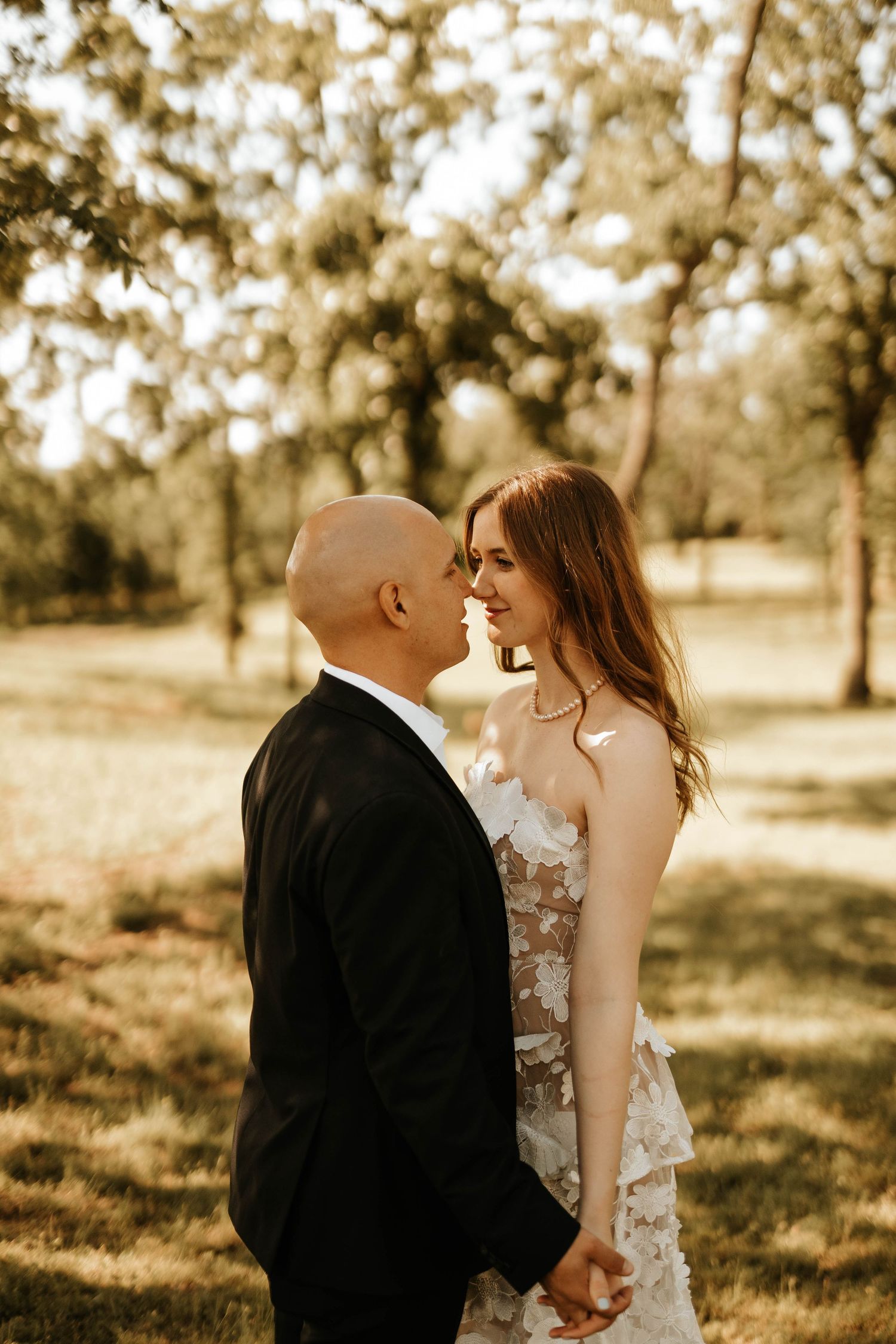 Romantic couple shares tender moment during sunset wedding photoshoot.