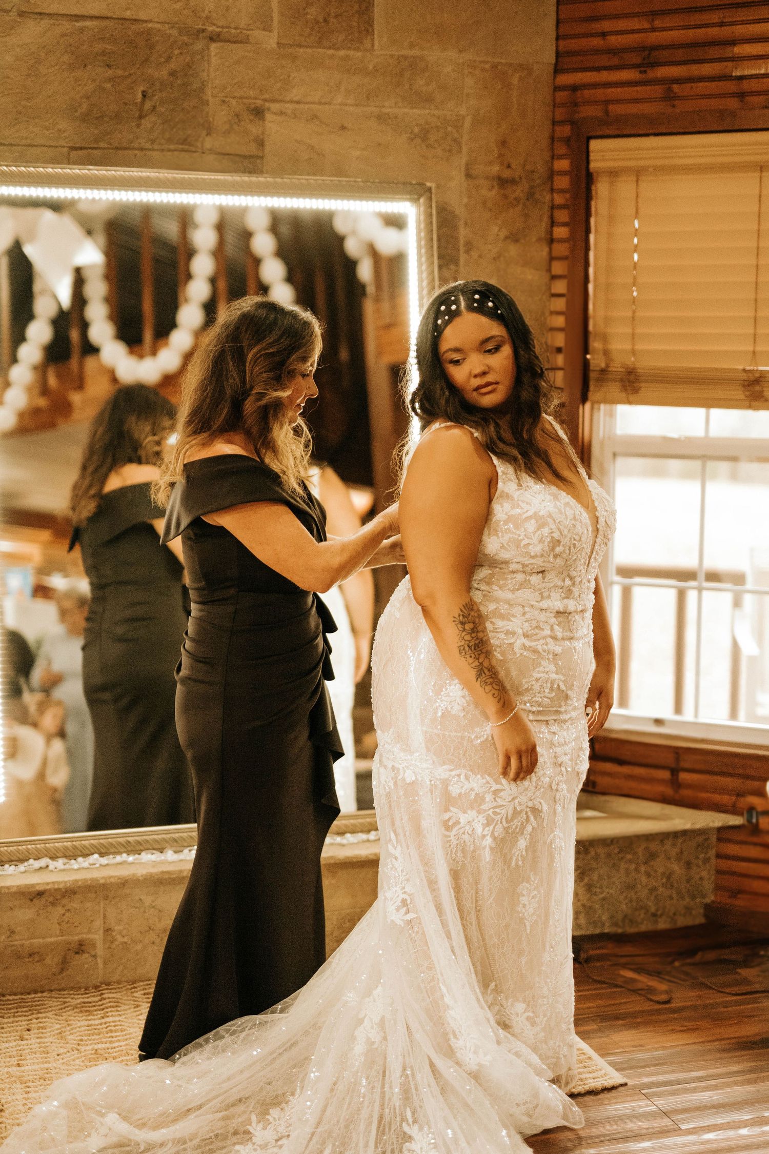 Wedding dress fitting session with bride trying on elegant lace gown in boutique.