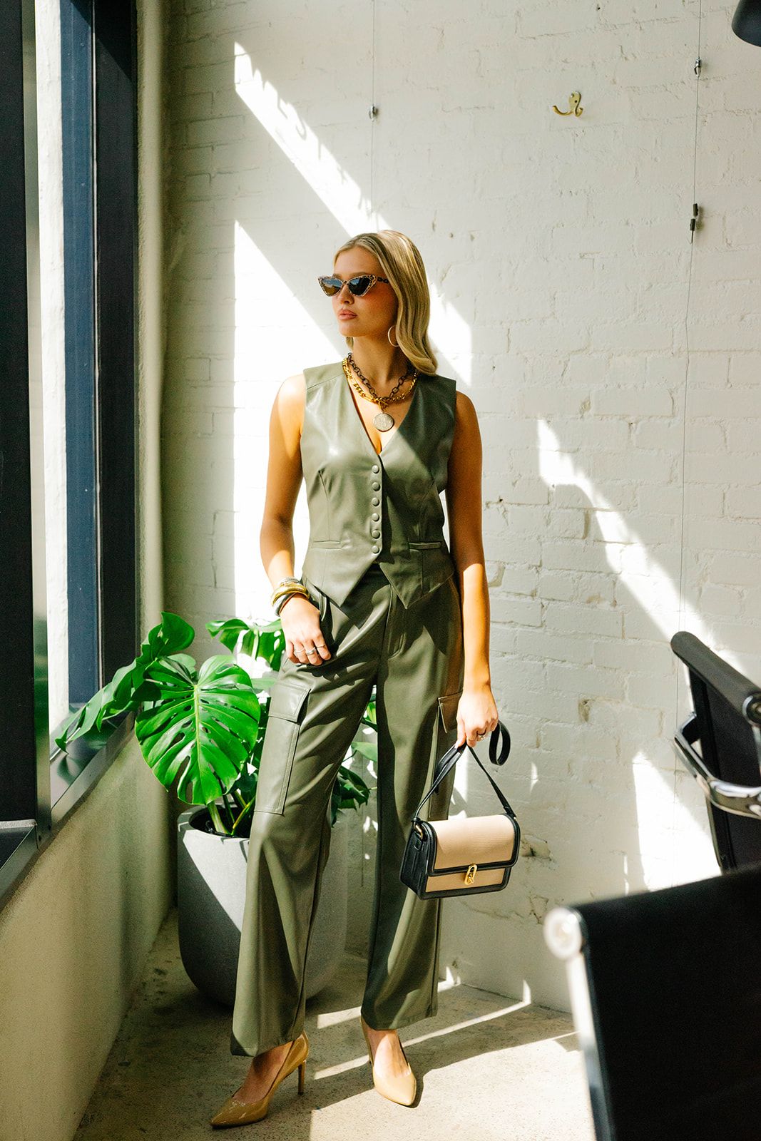 Stylish photoshoot in bright studio space with monstera plants and natural lighting.