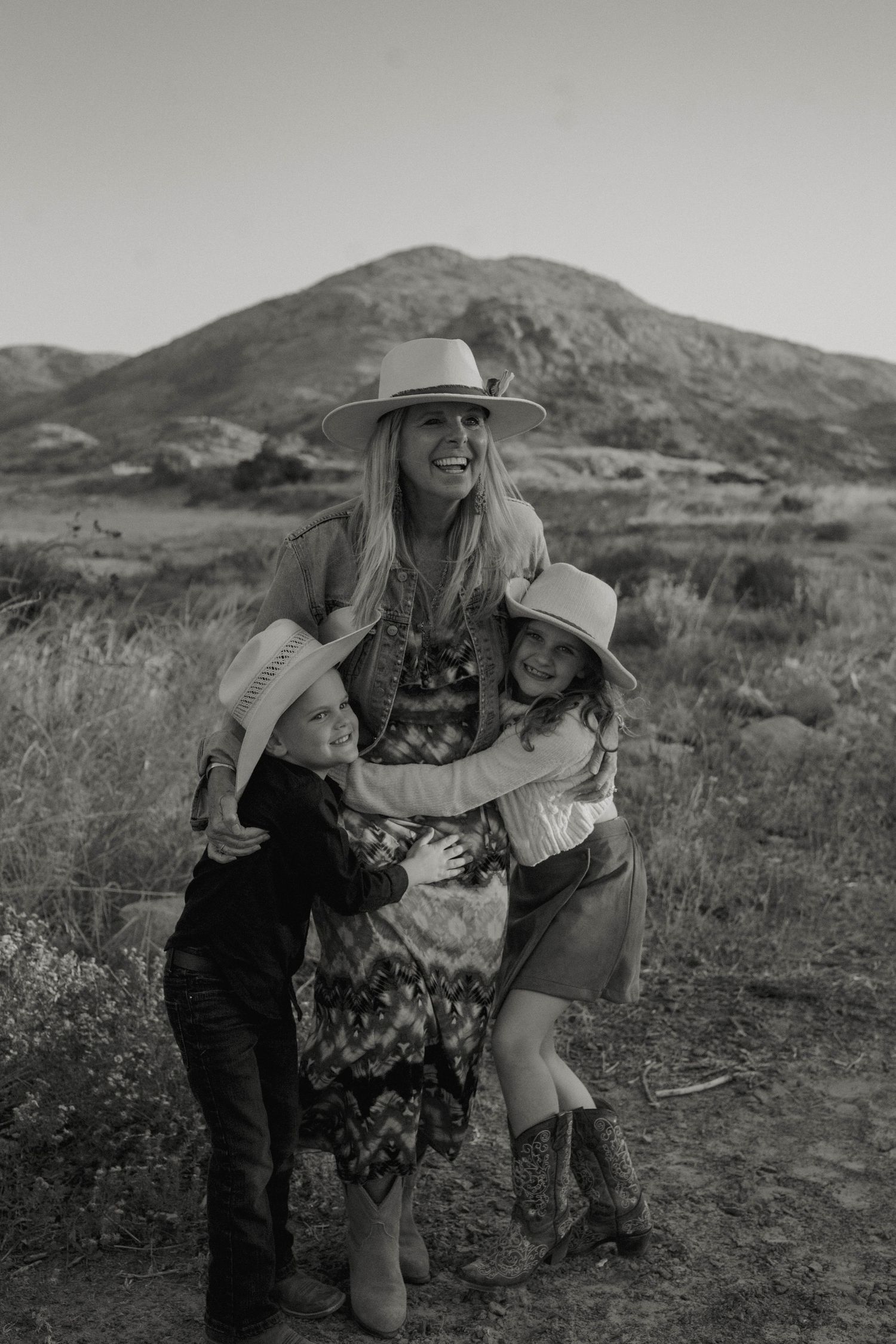 Joyful family moment captured against mountainous desert backdrop.