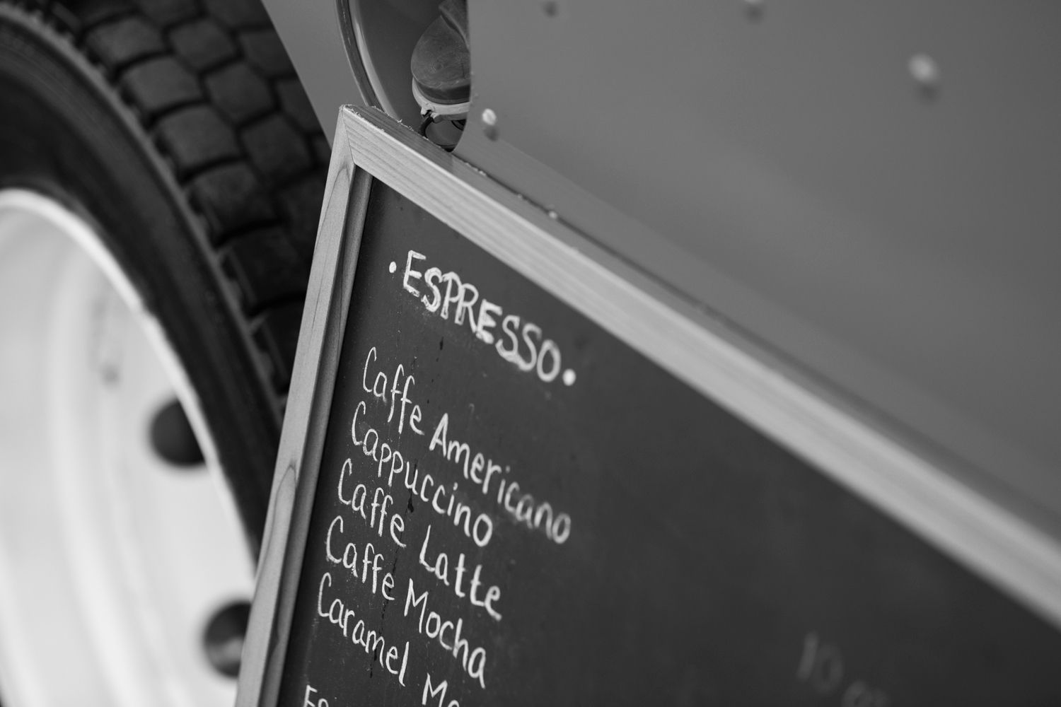 Close-up of espresso menu written on chalkboard mounted on food truck.