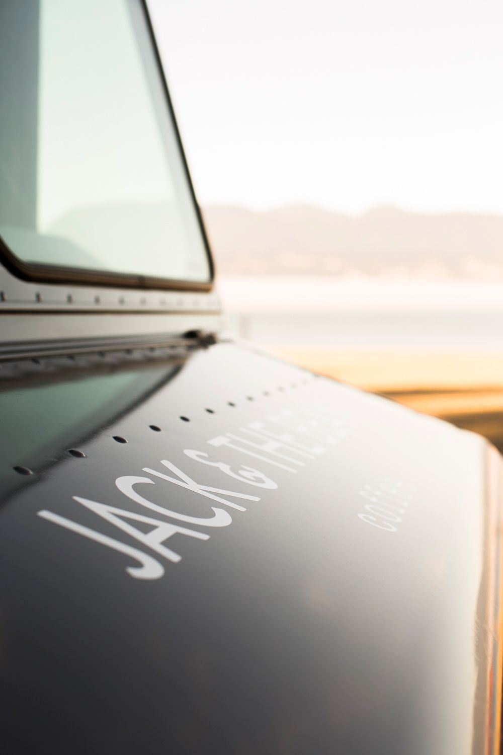 Close up of Jack coffee branding on the side of a vehicle during sunset.