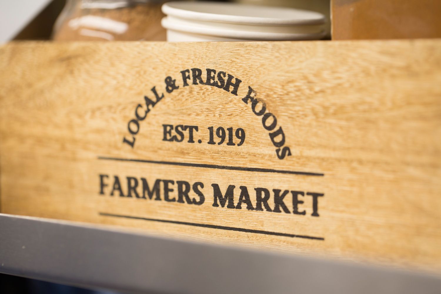 Wooden crate with farmers market logo and establishment date engraved.