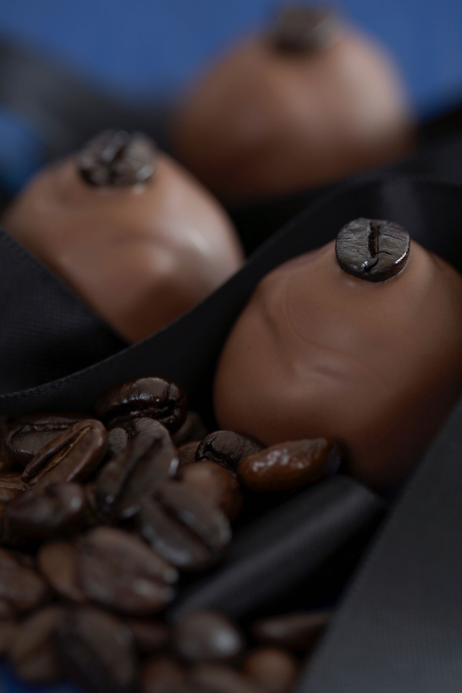 Artisanal chocolate bonbons with coffee beans on dark background.