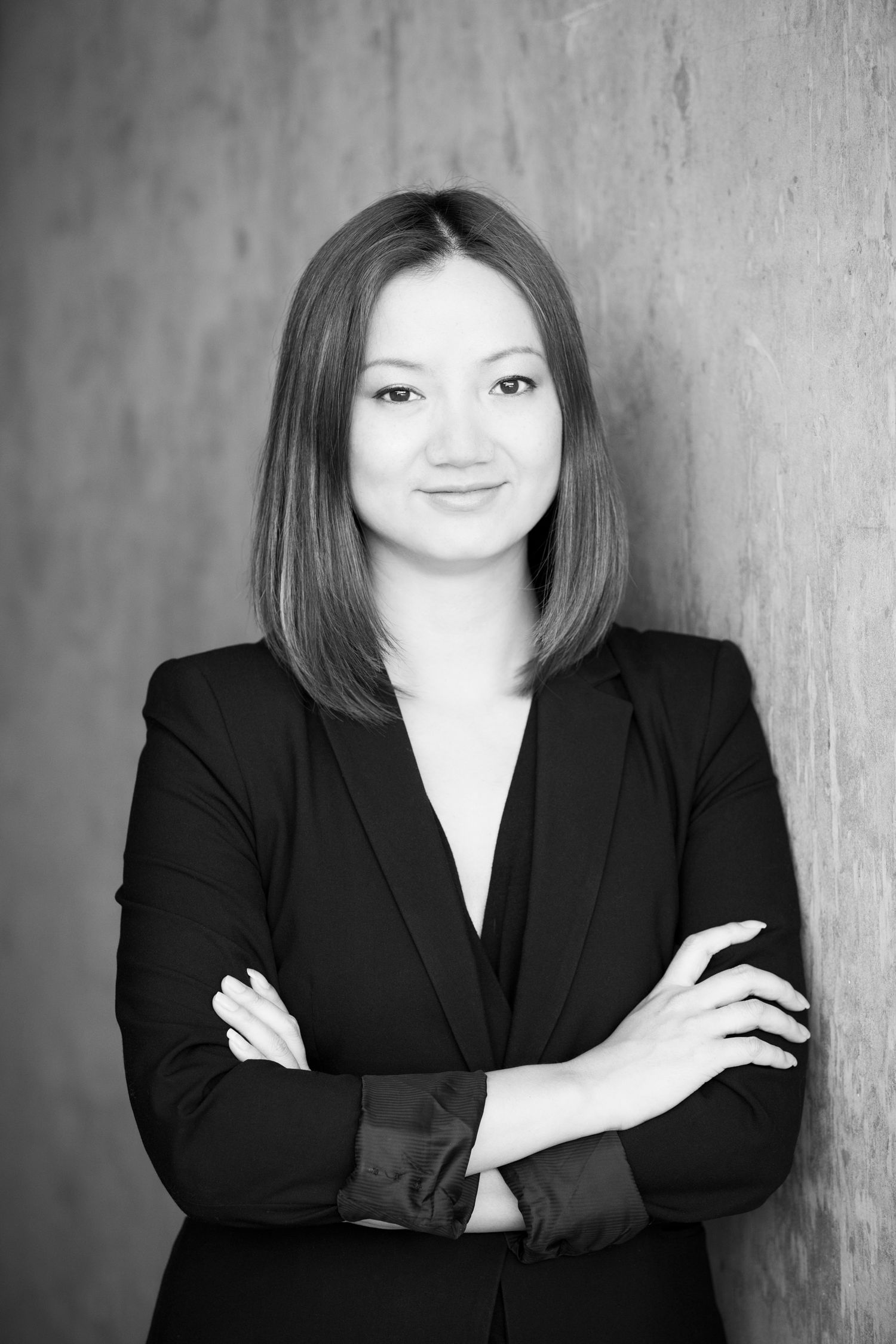 Black and white portrait series showing person in business attire against textured wall.