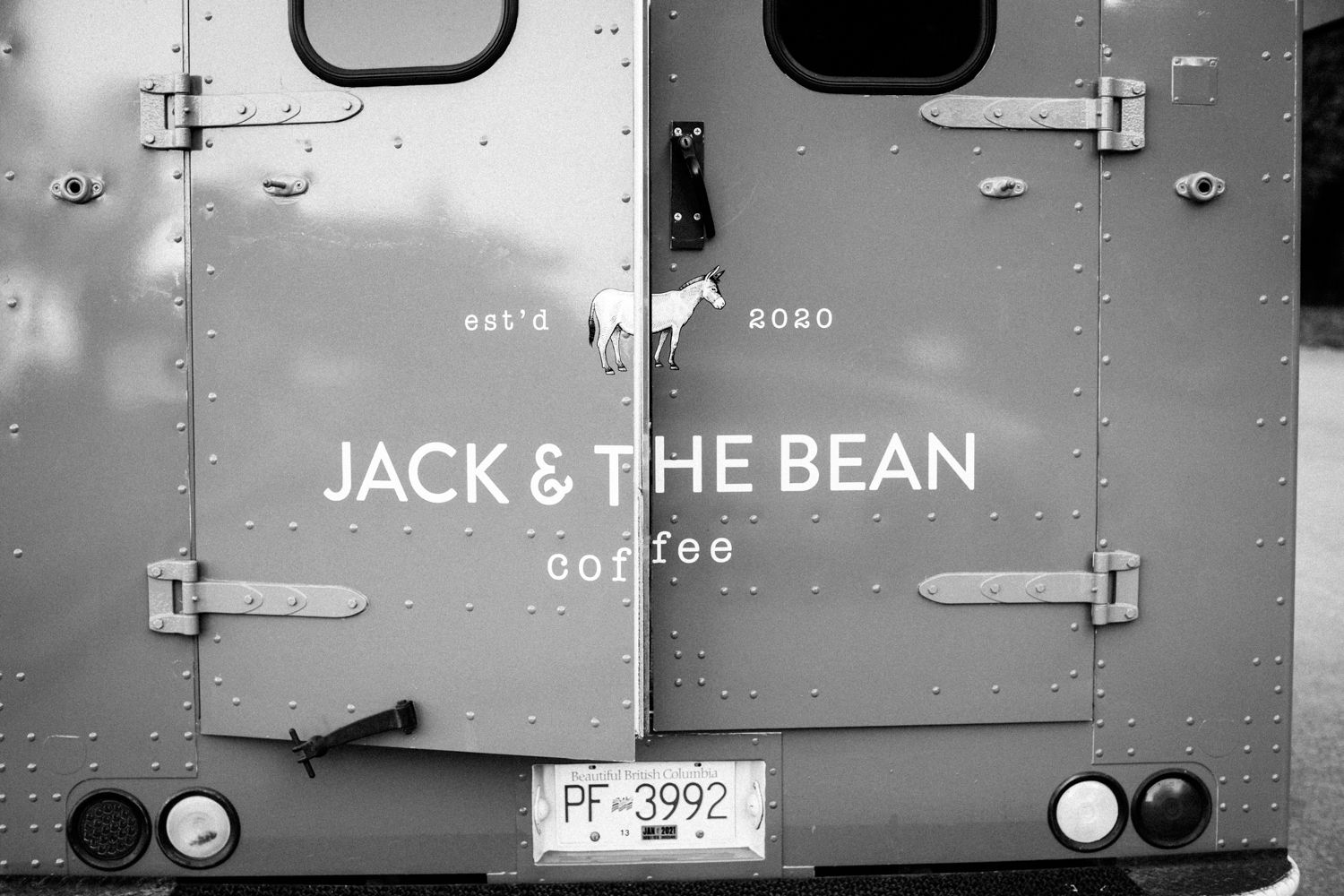 Back of a silver coffee truck displaying 'JACK & THE BEAN coffee' branding in black and white.