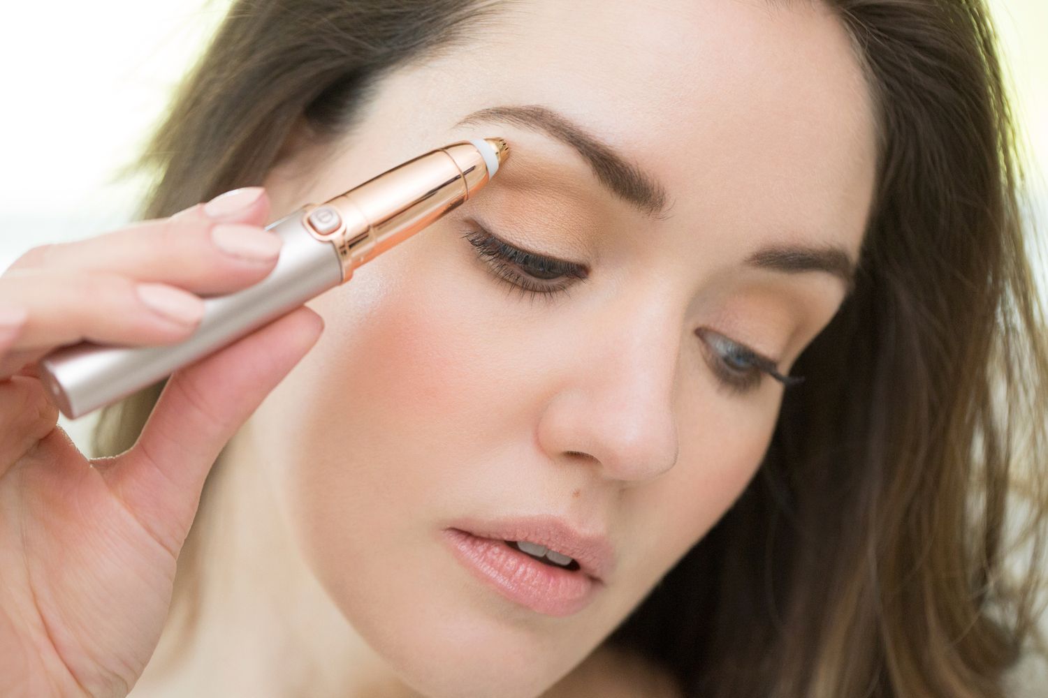 Woman using facial beauty device showing skincare treatment technique.