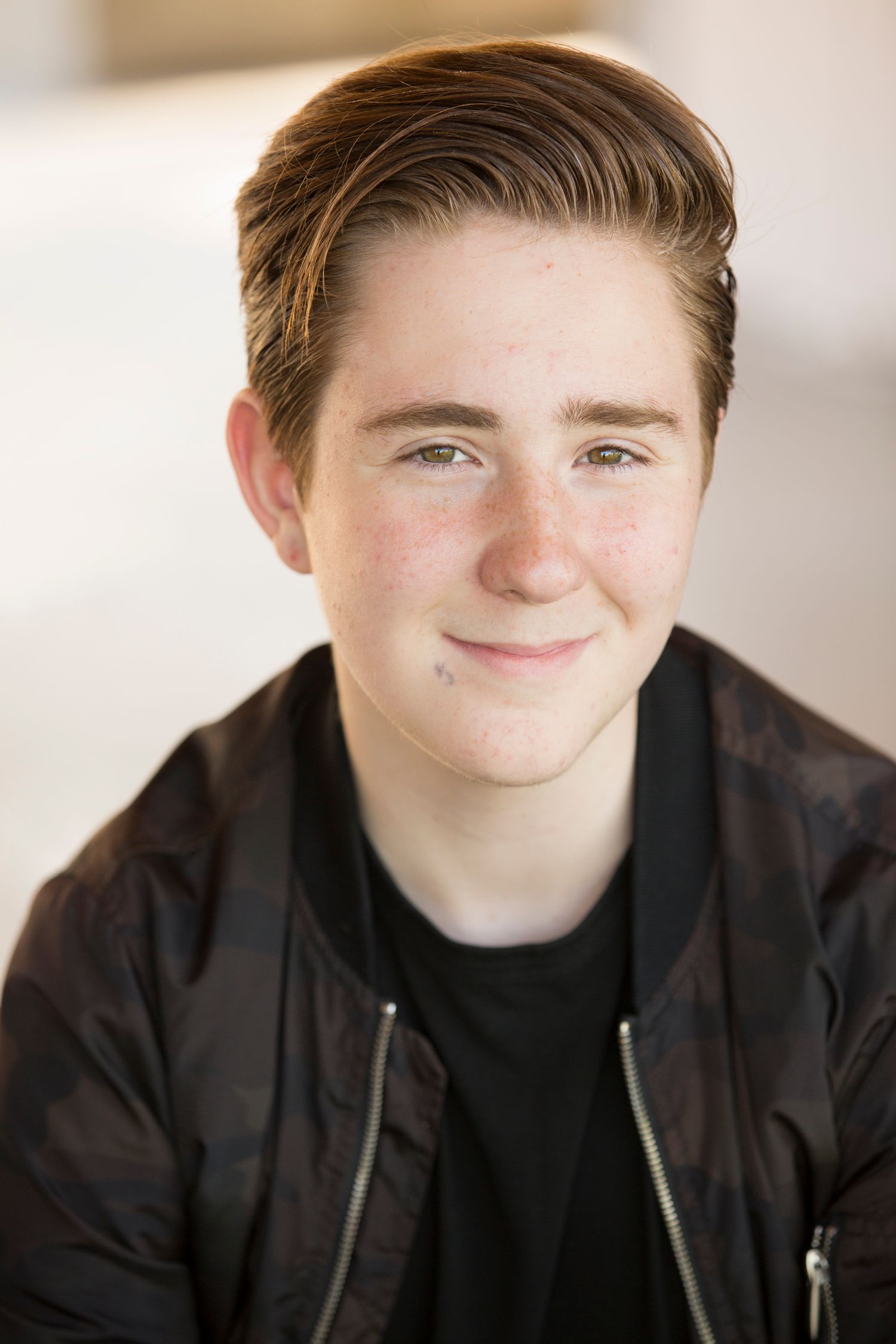 Portrait series in dark jacket against light background.