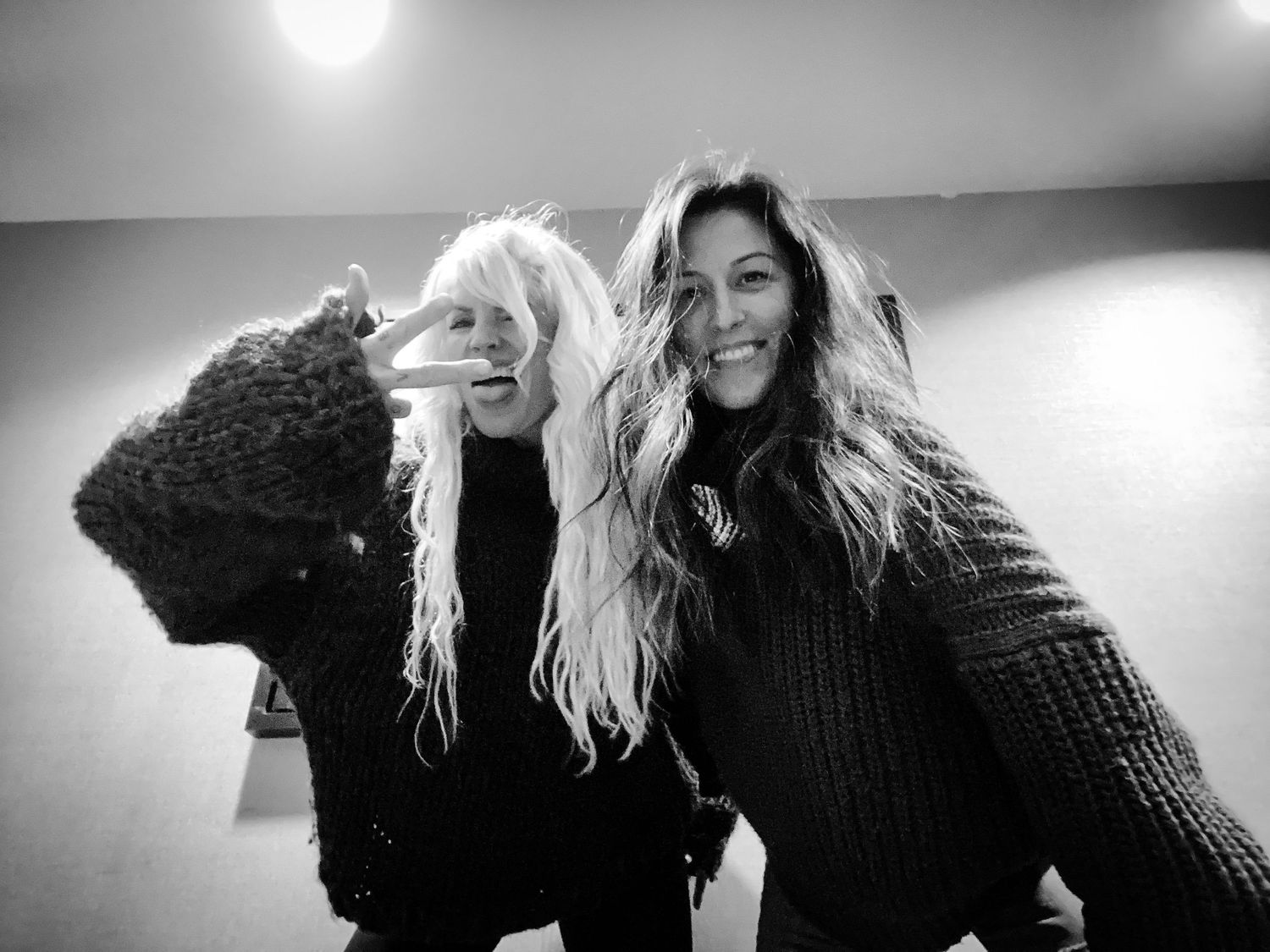 Black and white photo of two people laughing with long hair.