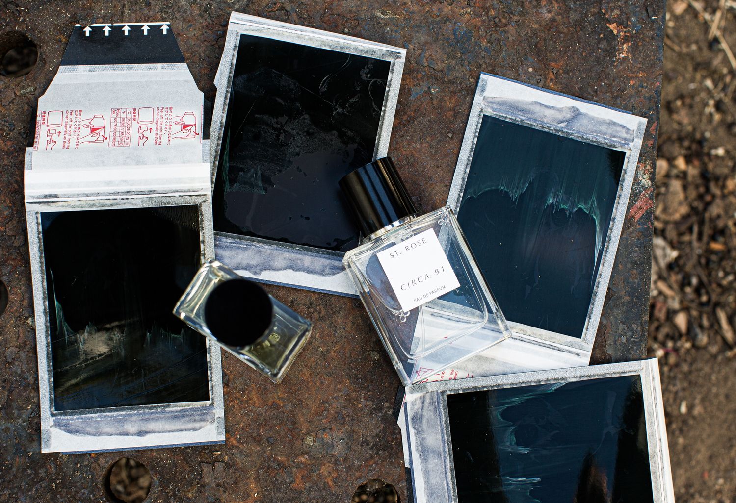 Broken smartphone screens and glass fragments arranged on rustic metal surface.