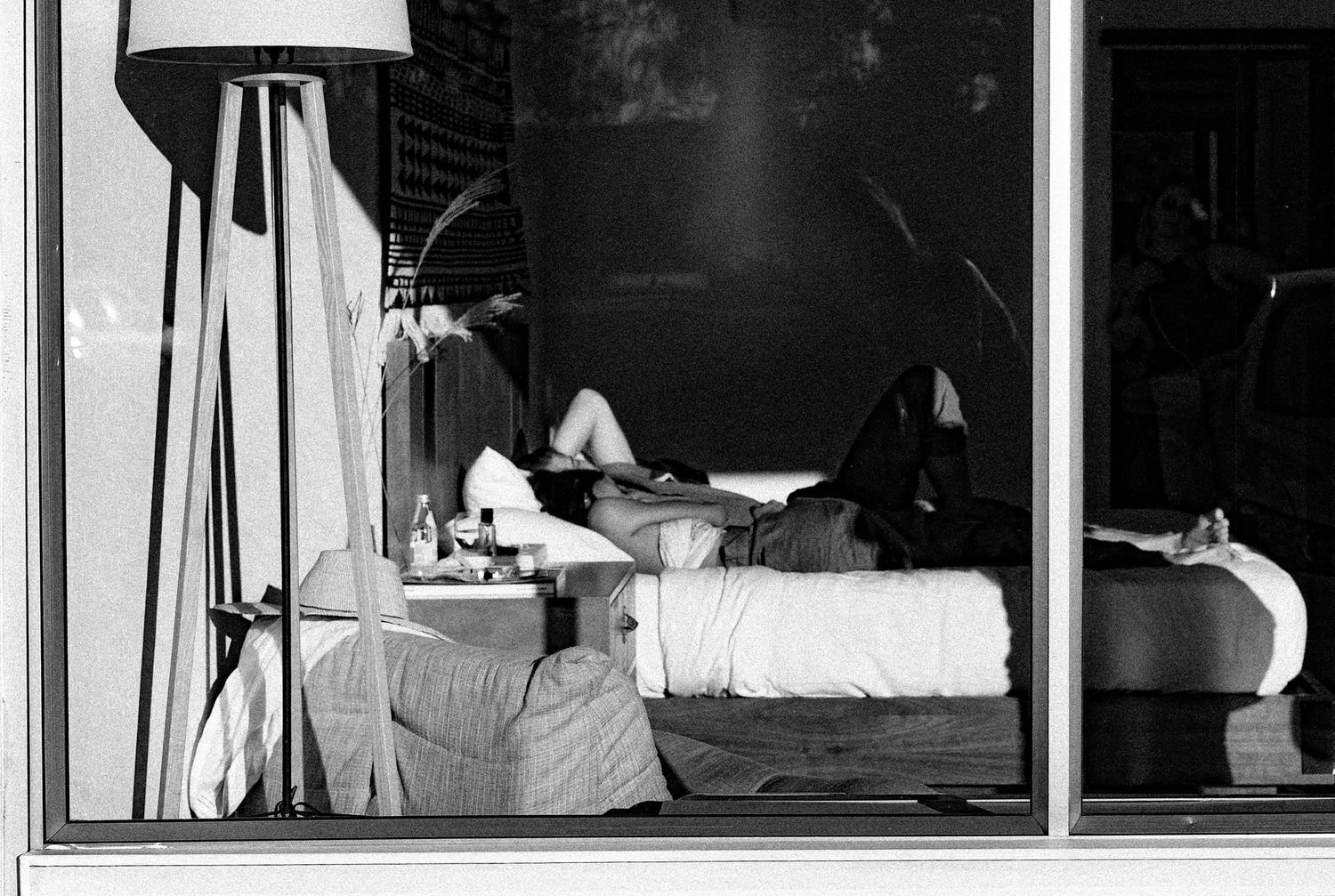 Black and white view through apartment windows showing interior living spaces.