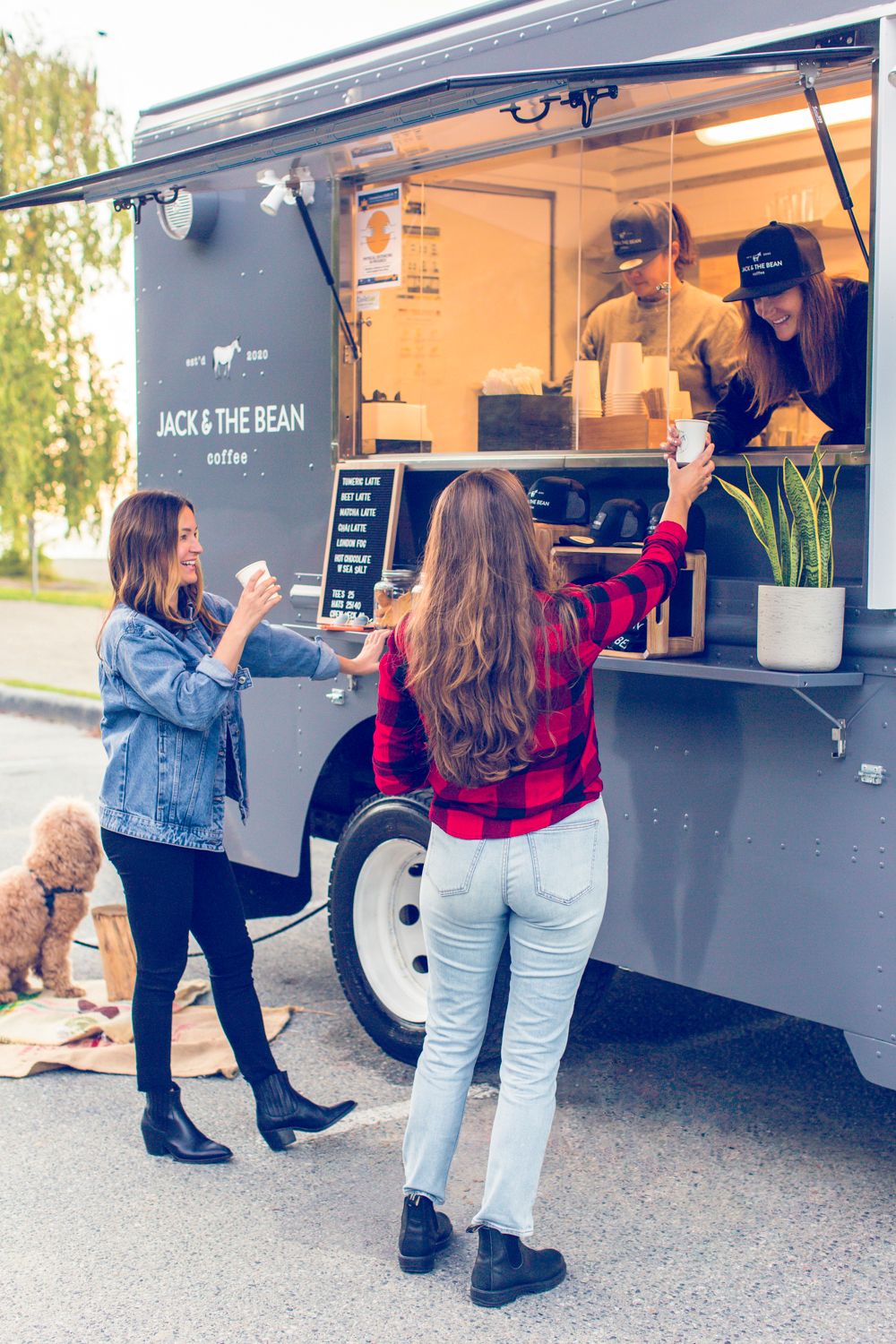 Customers ordering from a Jack & The Bean coffee food truck parked outdoors with vendors serving through the window.