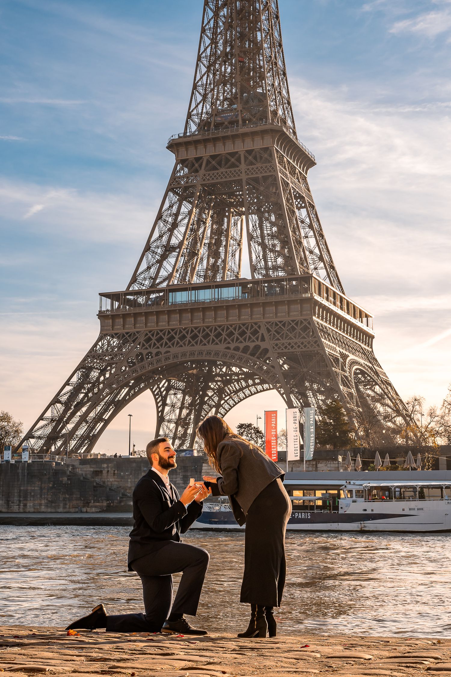 Marriage proposal silhouette in front of Eiffel Tower during golden hour.