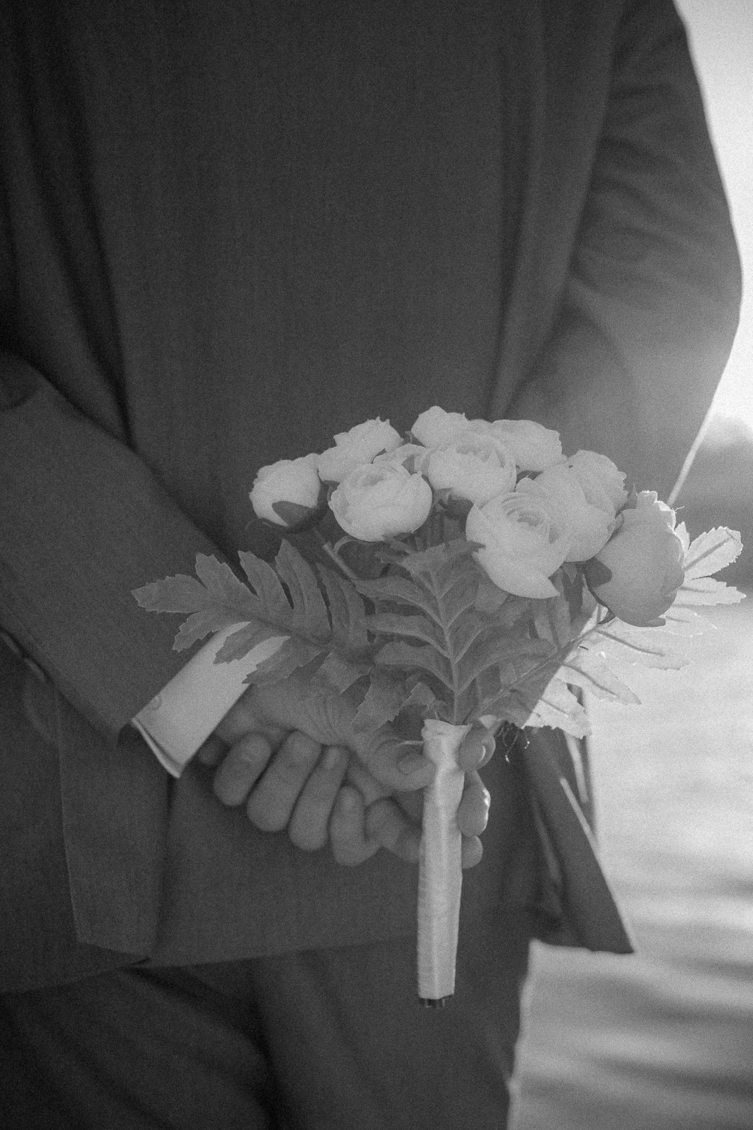 A sequence of black and white images showing hands holding a small floral bouquet wrapped in white ribbon.