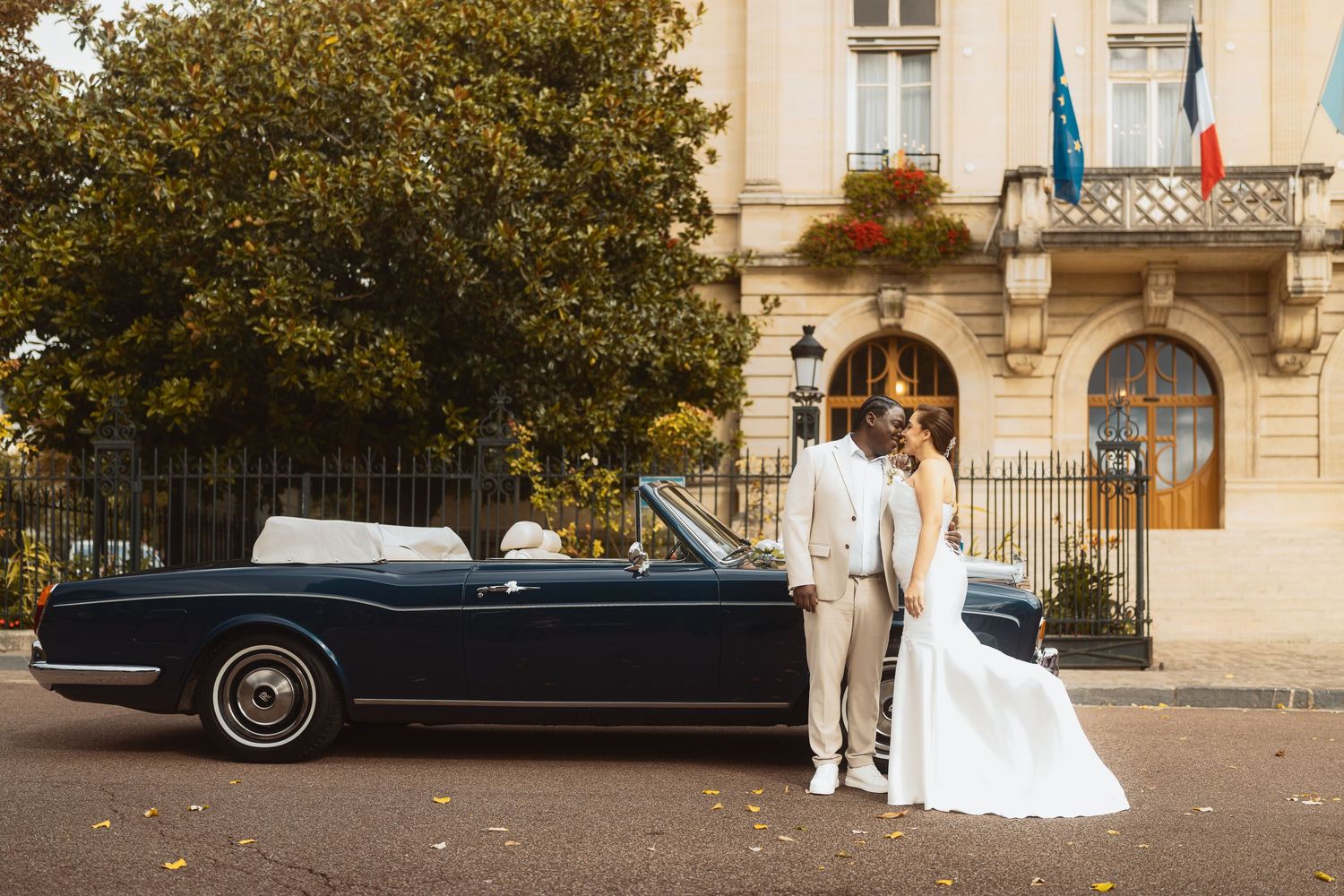A series of five wedding photos showing a vintage car and couple outside an elegant stone building.