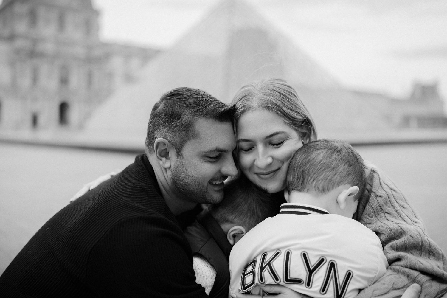 A black and white intimate family portrait showing affection and closeness while wearing a Brooklyn sweater.