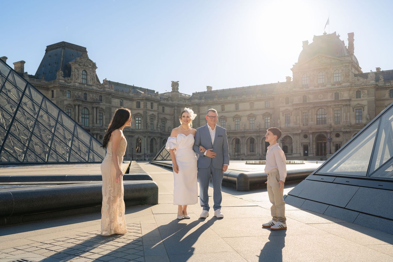 Wedding ceremony taking place in front of iconic Louvre pyramid.