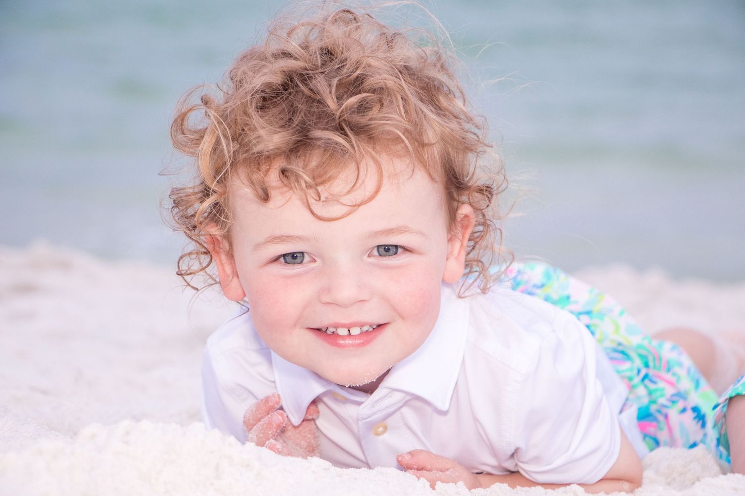 Close-up beach portraits capturing joyful expressions against ocean backdrop.