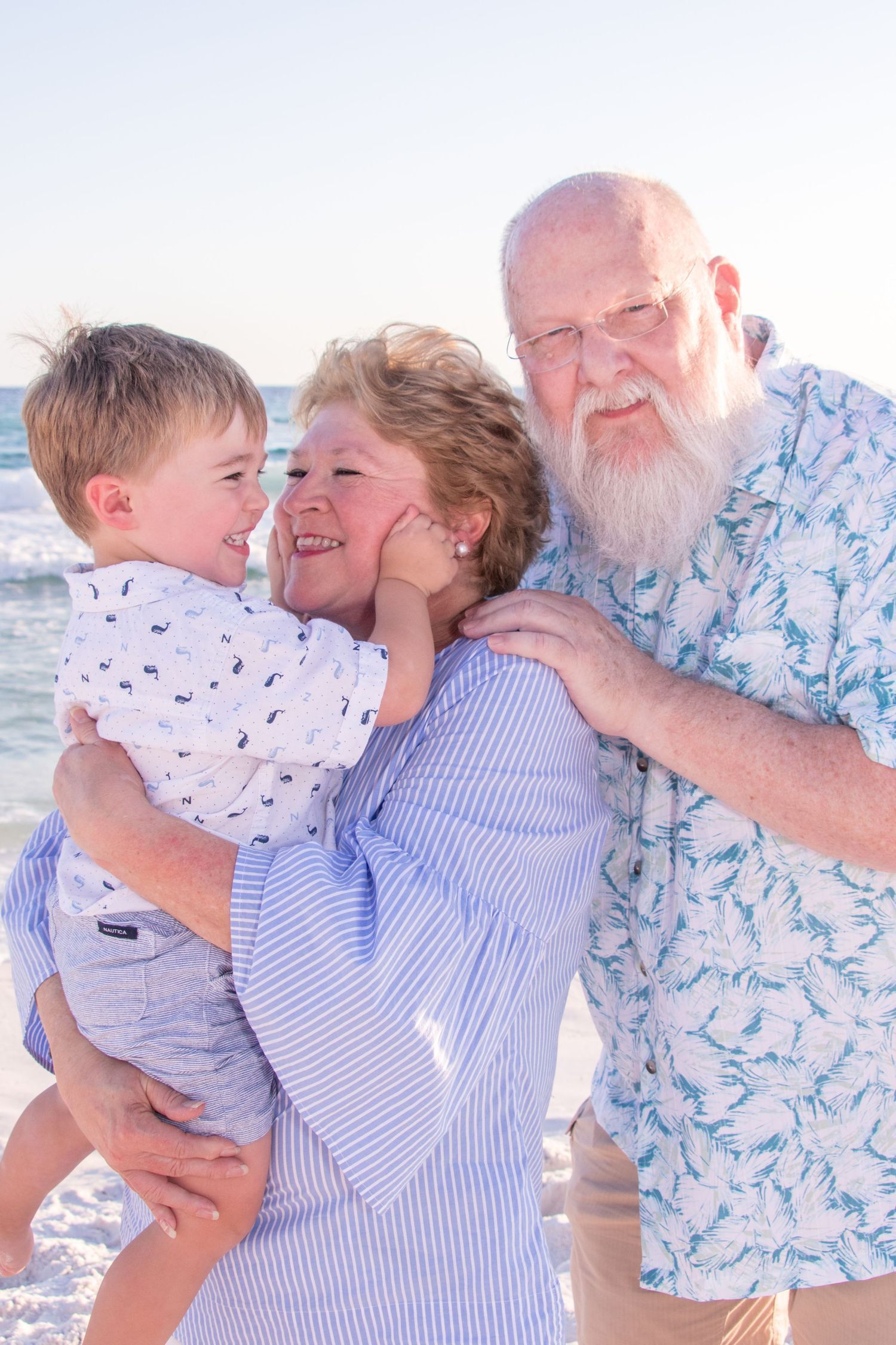 Three generations share a joyful moment together on the beach during sunset.
