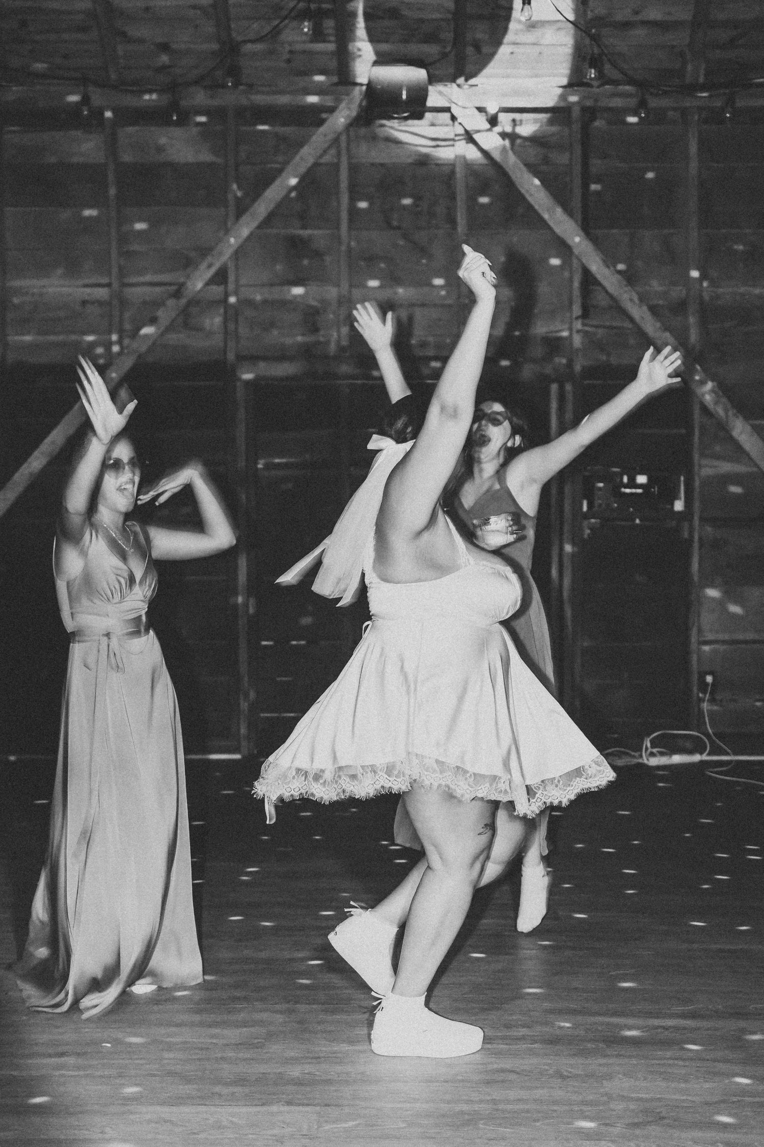 Dancers in vintage ballet costumes perform on stage with dramatic lighting and expressive arm movements.
