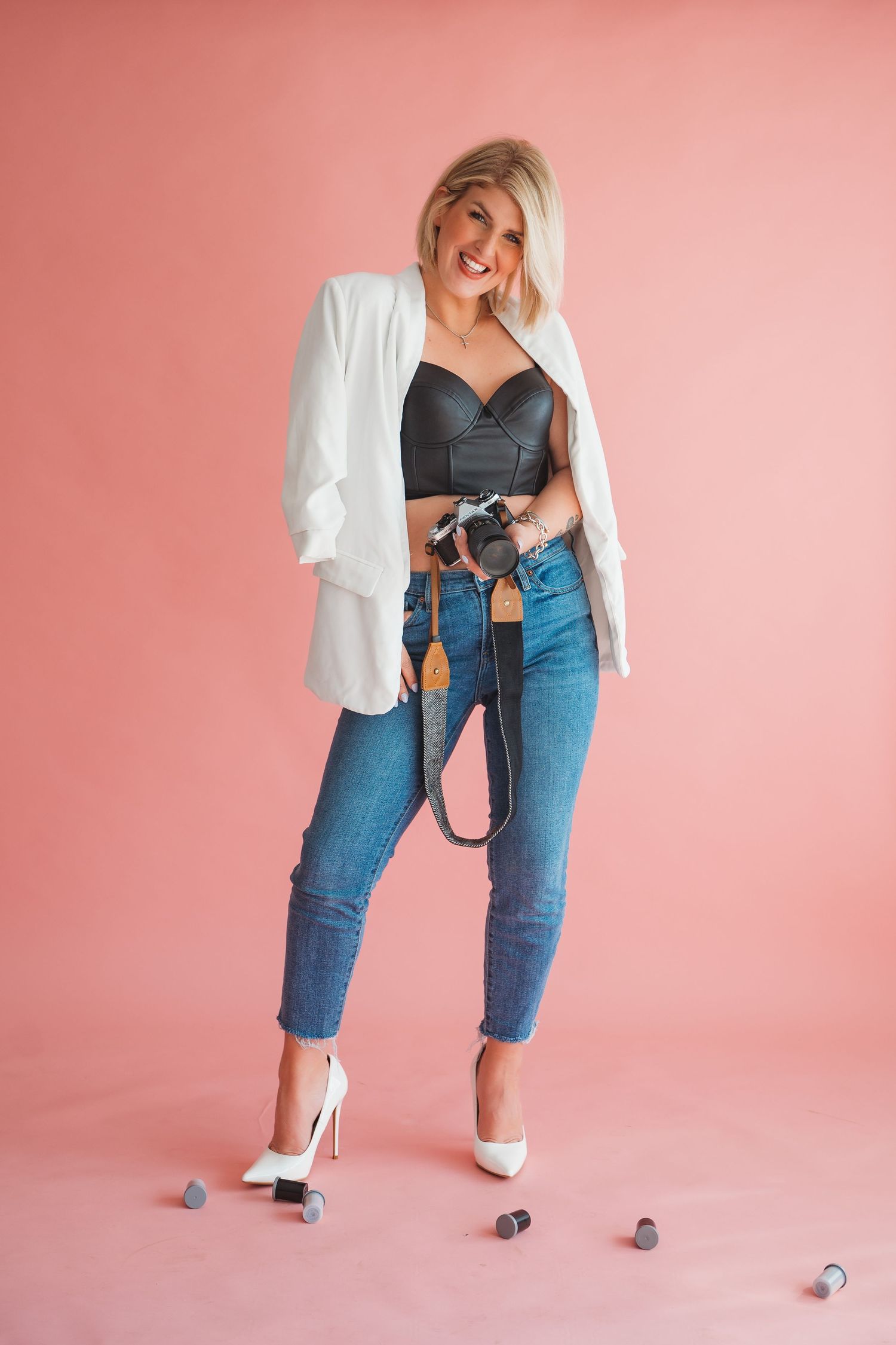 A playful fashion sequence shows a person in jeans and white blazer interacting with a toy car on a pink backdrop.