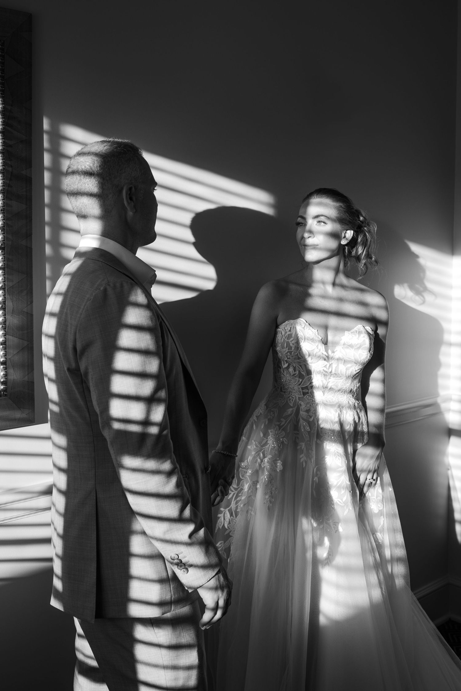 Dramatic black and white photo series showing figures casting striped window blind shadows in moody lighting.