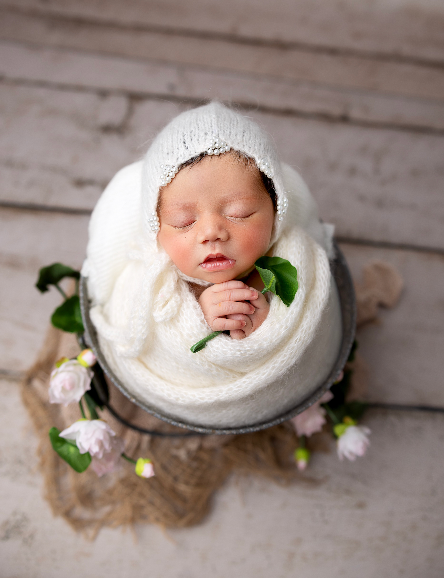 Newborn baby girl wrapped in soft neutral tones in Everett studio